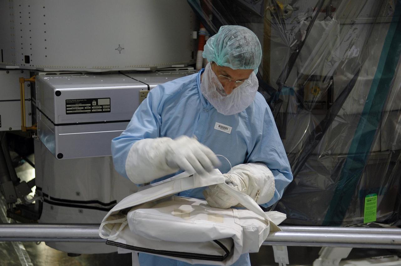 KENNEDY SPACE CENTER, FLA. -  In the Space Station Processing Facility at NASA's Kennedy Space Center, STS-115  Mission Specialist Daniel Burbank is practicing folding a sequential shunt unit launch to activation multilayer installation blanket. Burbank and other crew members are at the center for Crew Equipment Interface Test activities.  Equipment familiarization is a routine part of astronaut training and launch preparations.  The mission will deliver the second port truss segment, the P3/P4 Truss, to attach to the first port truss segment, the P1 Truss, as well as deploy solar array set 2A and 4A.  Launch on Space Shuttle Atlantis is scheduled for late August.  Photo credit: NASA/Kim Shiflett