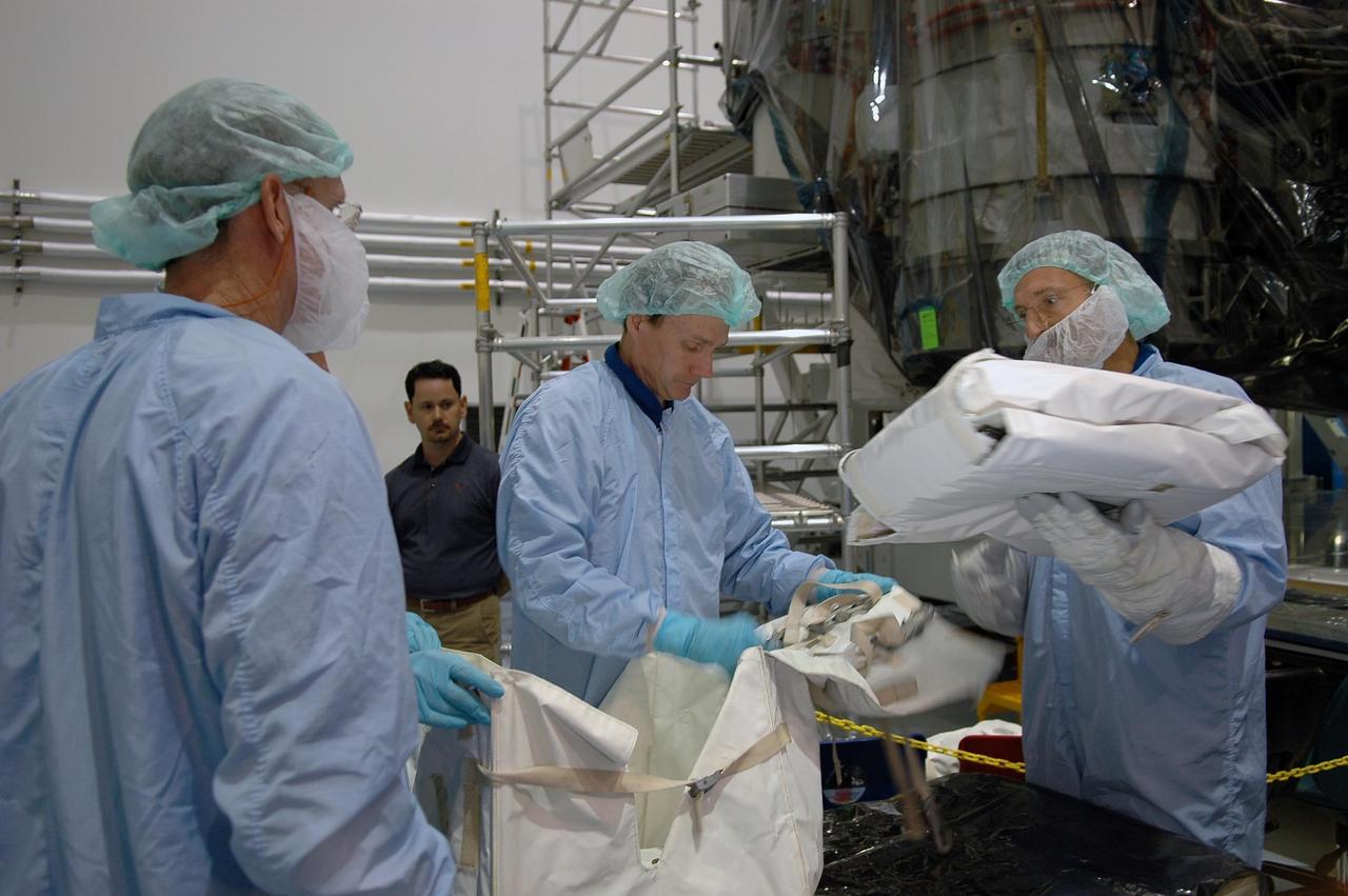 KENNEDY SPACE CENTER, FLA. - In the Space Station Processing Facility at NASA's Kennedy Space Center, STS-115 Mission Specialists Joe Tanner, Heidemarie Stefanyshyn-Piper, Steve Maclean and Dan Burbank are fit checking sequential shunt unit, electronics control unit and multiplexer demultiplexer launch to activation multi-layer installation blankets in a large Orbital Replaceable Unit transfer bag. They and other crew members are at the center for Crew Equipment Interface Test activities. Equipment familiarization is a routine part of astronaut training and launch preparations. The mission will deliver the second port truss segment, the P3/P4 Truss, to attach to the first port truss segment, the P1 Truss, as well as deploy solar array set 2A and 4A. Launch on Space Shuttle Atlantis is scheduled for late August. Photo credit: NASA/Kim Shiflett
