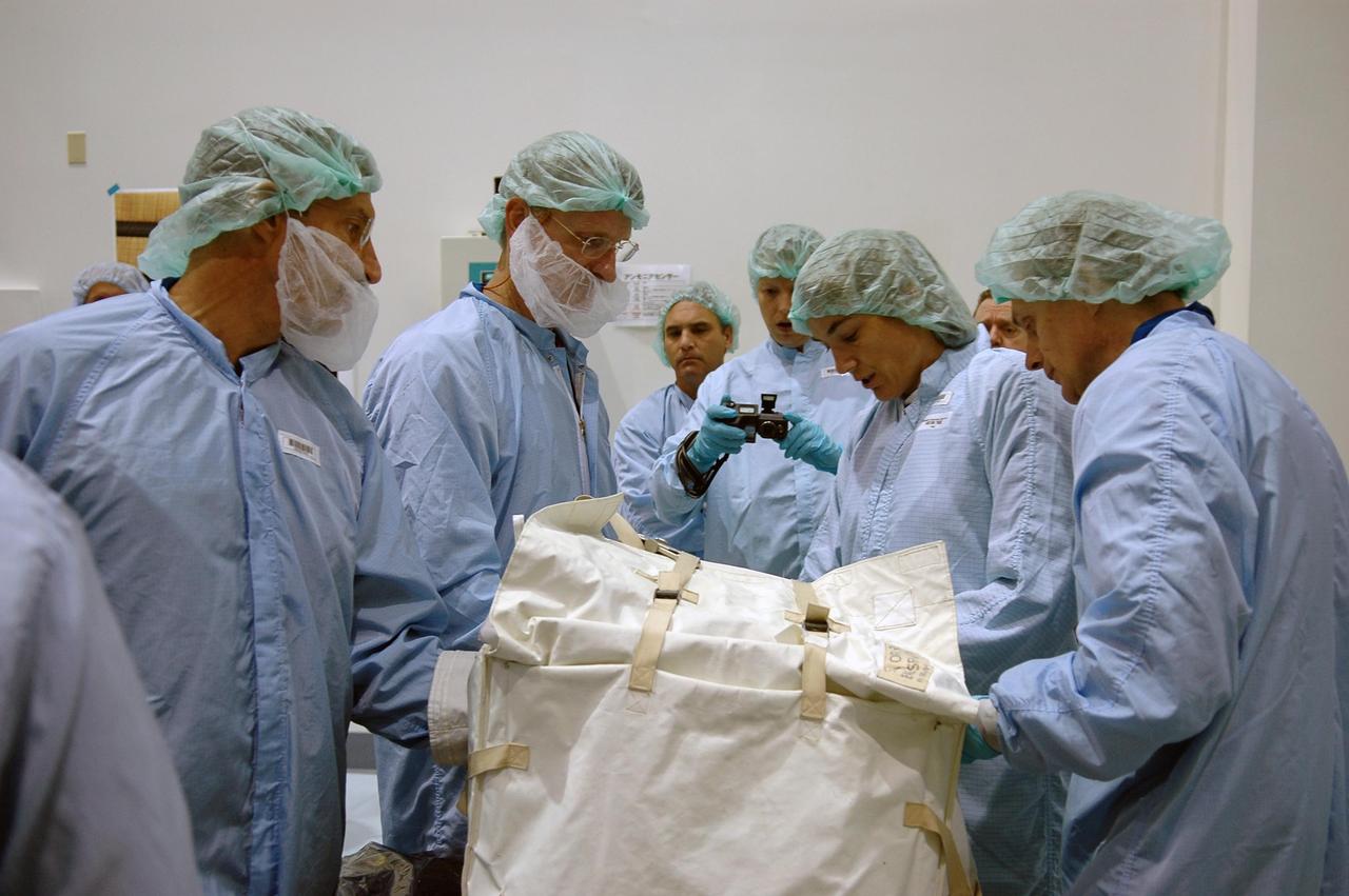 KENNEDY SPACE CENTER, FLA. - In the Space Station Processing Facility at NASA's Kennedy Space Center, STS-115 Mission Specialists (foreground, from left) Daniel Burbank, Joseph Tanner, Heidemarie Stefanyshyn-Piper, and Steve Maclean are fit checking a sequential shunt unit, electronics control unit and multiplexer de-multiplexer launch to activation multi-layer installation blankets in a large Orbital Replaceable Unit transfer bag. They and other crew members are at the center for Crew Equipment Interface Test activities. Equipment familiarization is a routine part of astronaut training and launch preparations. The mission will deliver the second port truss segment, the P3/P4 Truss, to attach to the first port truss segment, the P1 Truss, as well as deploy solar array set 2A and 4A. Launch on Space Shuttle Atlantis is scheduled for late August. Photo credit: NASA/Kim Shiflett