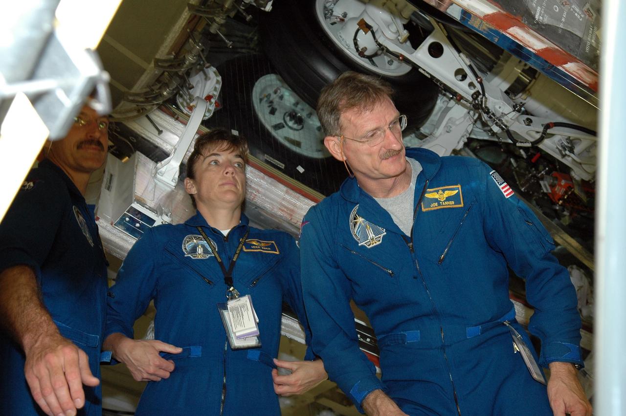 KENNEDY SPACE CENTER, FLA. -   In the Orbiter Processing Facility, STS-115 crew members are examining the orbiter Atlantis, the designated launch vehicle for their mission.  From left are Mission Specialists Daniel Burbank, Heidemarie Stefanyshyn-Piper and Joseph Tanner.  The crew is at the center for Crew Equipment Interface Test activities, which involves equipment familiarization,  a routine part of astronaut training and launch preparations.  The mission will deliver the second port truss segment, the P3/P4 Truss, to attach to the first port truss segment, the P1 Truss, as well as deploy solar array set 2A and 4A.  Launch on Space Shuttle Atlantis is scheduled for late August.  Photo credit: NASA/Kim Shiflett