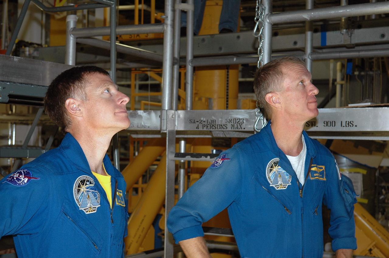 KENNEDY SPACE CENTER, FLA. -   In the Orbiter Processing Facility, STS-115 crew members examine tiles on the orbiter Atlantis,  the designated launch vehicle for their mission. From left are Pilot Christopher Ferguson and Commander Brent Jett. The crew is at the center for Crew Equipment Interface Test activities, which involves equipment familiarization,  a routine part of astronaut training and launch preparations.  The mission will deliver the second port truss segment, the P3/P4 Truss, to attach to the first port truss segment, the P1 Truss, as well as deploy solar array set 2A and 4A.  Launch on Space Shuttle Atlantis is scheduled for late August.  Photo credit: NASA/Kim Shiflett
