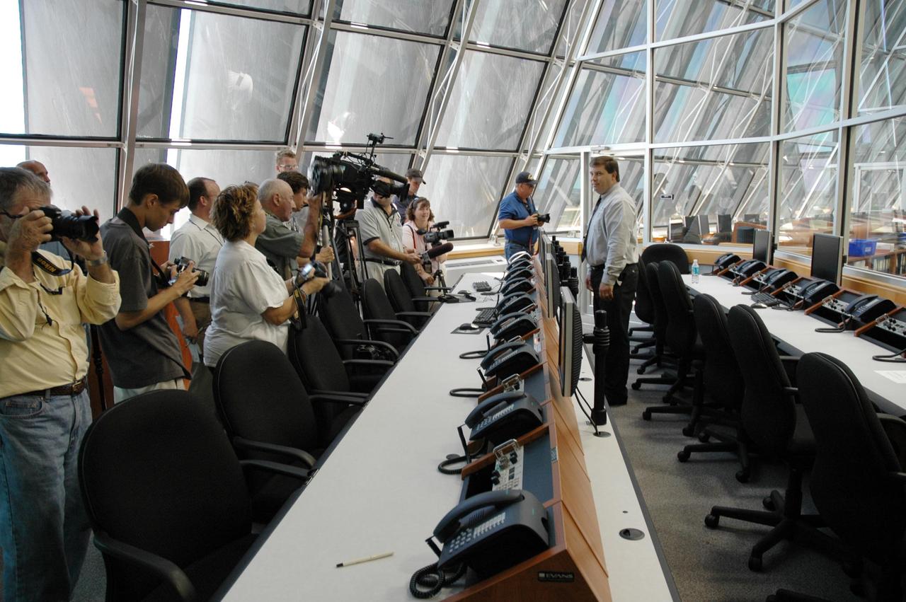 KENNEDY SPACE CENTER, FLA. - Ted Mosteller (right), NASA test director, briefs the media about Firing Room 4 (FR4), which has been undergoing renovations for two years. FR4 is now designated the primary firing room for all remaining shuttle launches, and will also be used daily to manage operations in the Orbiter Processing Facilities and for integrated processing for the shuttle. The firing room now includes sound-suppressing walls and floors, new humidity control, fire-suppression systems and consoles, support tables with computer stations, communication systems and laptop computer ports. FR 4 also has power and computer network connections and a newly improved Checkout, Control and Monitor Subsystem. The renovation is part of the Launch Processing System Extended Survivability Project that began in 2003. United Space Alliance's Launch Processing System directorate managed the FR 4 project for NASA. Photo credit: NASA/Dimitri Gerondidakis