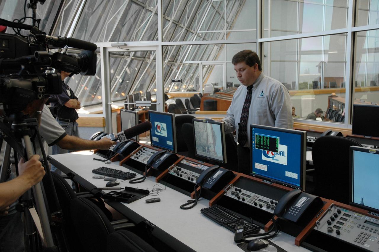 KENNEDY SPACE CENTER, FLA. - NASA Test Director Ted Mosteller (right) briefs the media about Firing Room 4 (FR4), which has been undergoing renovations for two years. FR4 is now designated the primary firing room for all remaining shuttle launches, and will also be used daily to manage operations in the Orbiter Processing Facilities and for integrated processing for the shuttle. The firing room now includes sound-suppressing walls and floors, new humidity control, fire-suppression systems and consoles, support tables with computer stations, communication systems and laptop computer ports. FR 4 also has power and computer network connections and a newly improved Checkout, Control and Monitor Subsystem. The renovation is part of the Launch Processing System Extended Survivability Project that began in 2003. United Space Alliance's Launch Processing System directorate managed the FR 4 project for NASA. Photo credit: NASA/Dimitri Gerondidakis