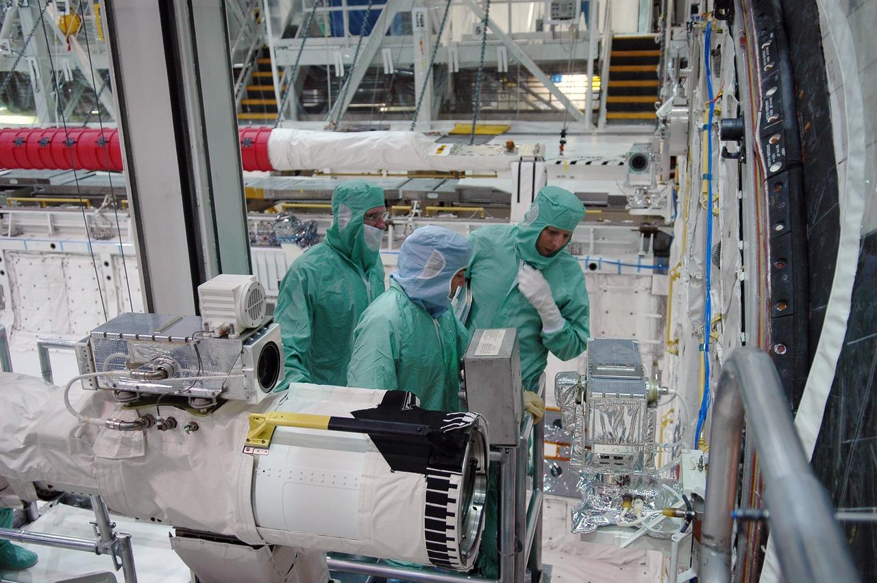 KENNEDY SPACE CENTER, FLA. -   In the Orbiter Processing Facility at NASA's Kennedy Space Center, STS-115 crew members inspect equipment in Atlantis's payload bay.  From left are Mission Specialists Joseph Tanner and Heidemarie Stefanyshyn-Piper. The crew is at KSC for Crew Equipment Interface Test activities, which involves equipment familiarization,  a routine part of astronaut training and launch preparations.  The STS-115 mission will deliver the second port truss segment, the P3/P4 truss, to the International Space Station.  The crew will attach the P3 to the first port truss segment, the P1 truss, as well as deploy solar array set 2A and 4A.  Launch on Space Shuttle Atlantis is scheduled for late August. Photo credit: NASA/Kim Shiflett