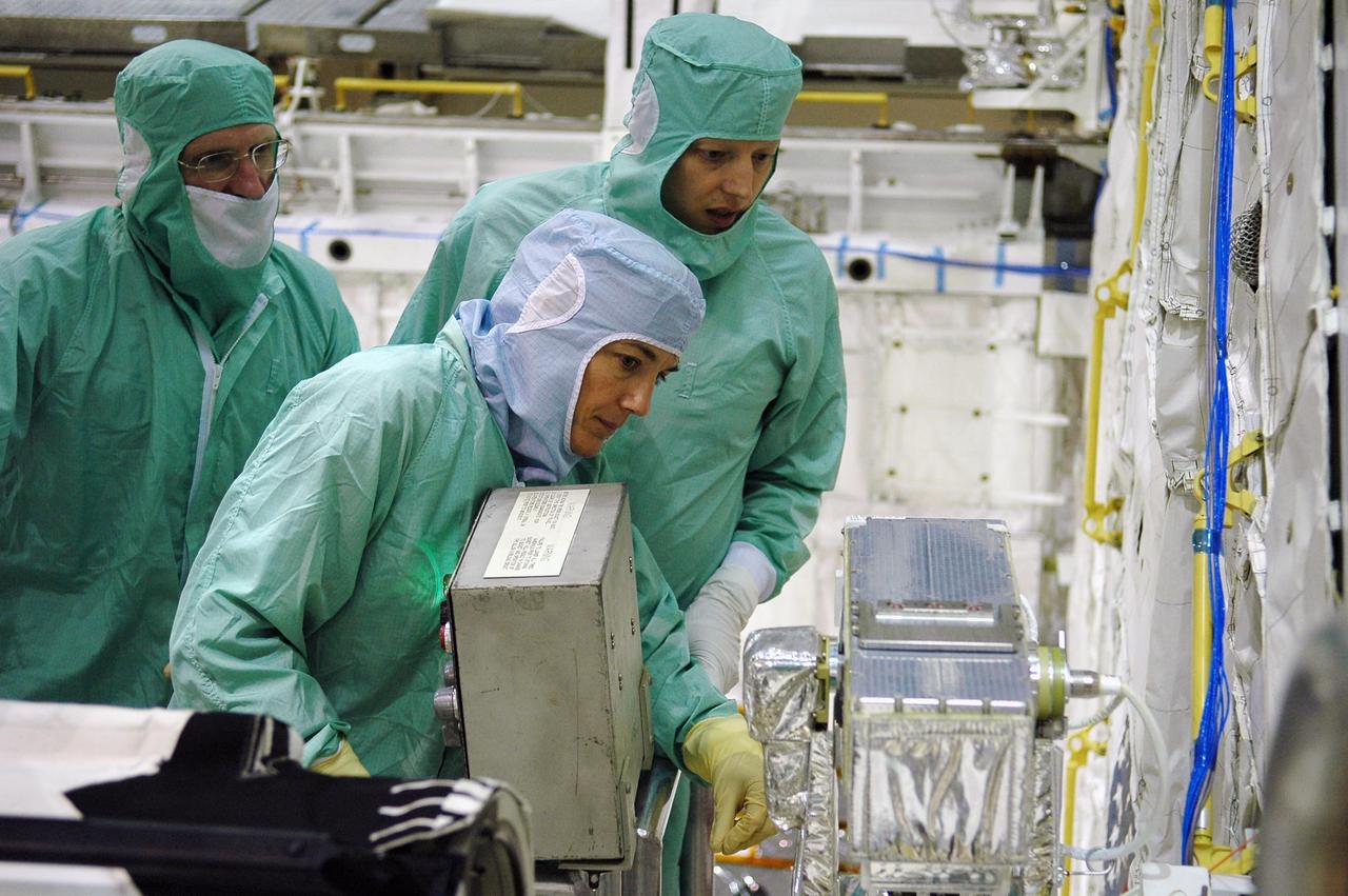 KENNEDY SPACE CENTER, FLA. -   In the Orbiter Processing Facility at NASA's Kennedy Space Center, STS-115 crew members inspect equipment in Atlantis's payload bay.  From left are Mission Specialists Joseph Tanner and Heidemarie Stefanyshyn-Piper. The crew is at KSC for Crew Equipment Interface Test activities, which involves equipment familiarization,  a routine part of astronaut training and launch preparations.  The STS-115 mission will deliver the second port truss segment, the P3/P4 truss, to the International Space Station.  The crew will attach the P3 to the first port truss segment, the P1 truss, as well as deploy solar array set 2A and 4A.  Launch on Space Shuttle Atlantis is scheduled for late August. Photo credit: NASA/Kim Shiflett
