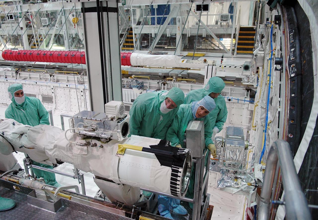 KENNEDY SPACE CENTER, FLA. -  In the Orbiter Processing Facility at NASA's Kennedy Space Center, STS-115 crew members inspect equipment in Atlantis's payload bay.  Looking at the orbiter boom sensor system are, from left, Mission Specialists Joseph Tanner and Heidemarie Stefanyshyn-Piper.  The crew is at KSC for Crew Equipment Interface Test activities, which involves equipment familiarization,  a routine part of astronaut training and launch preparations.  The STS-115 mission will deliver the second port truss segment, the P3/P4 truss, to the International Space Station.  The crew will attach the P3 to the first port truss segment, the P1 truss, as well as deploy solar array set 2A and 4A.  Launch on Space Shuttle Atlantis is scheduled for late August. Photo credit: NASA/Kim Shiflett