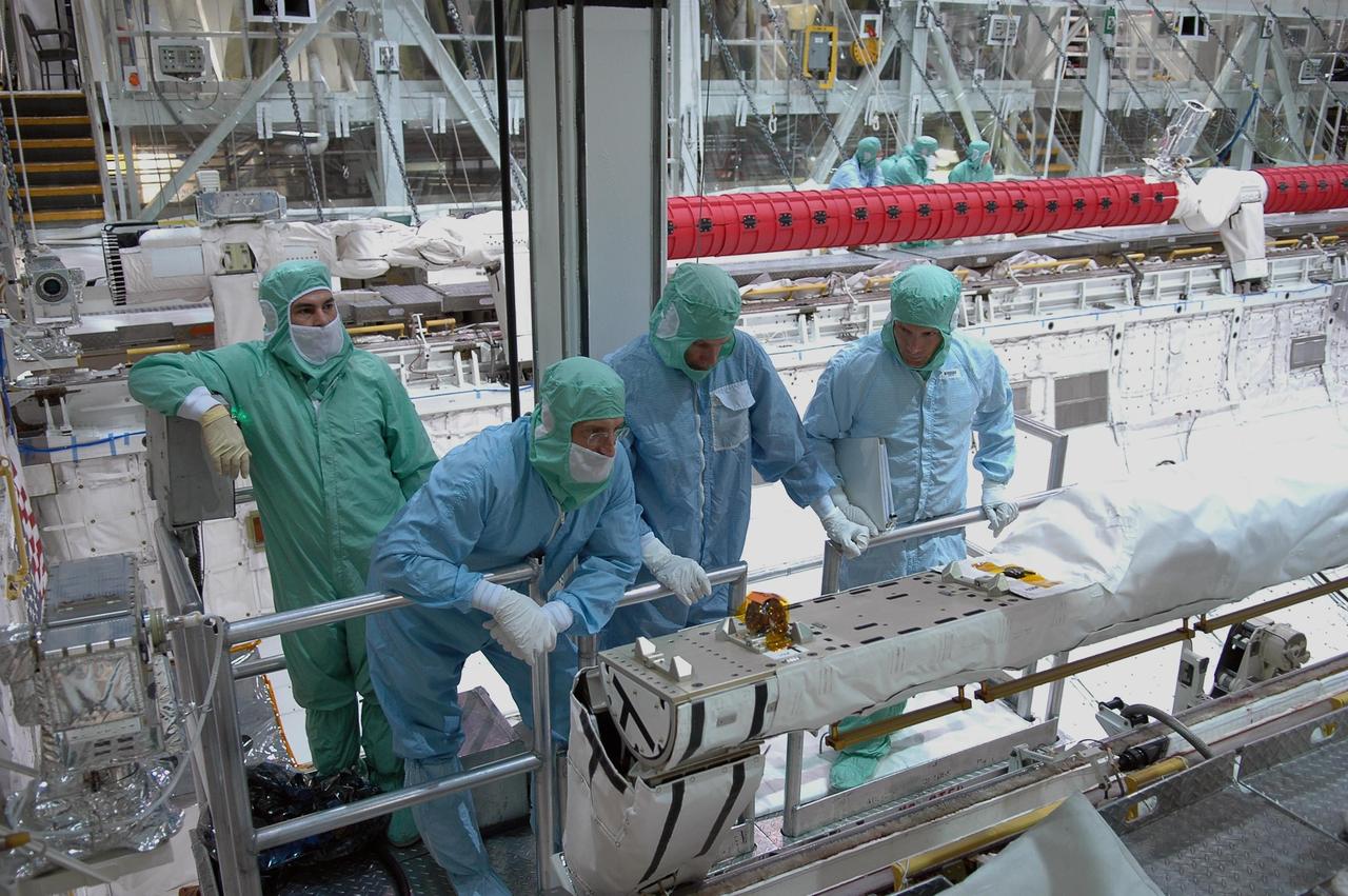 KENNEDY SPACE CENTER, FLA. -  In the Orbiter Processing Facility at NASA's Kennedy Space Center, STS-115 crew members inspect equipment in Atlantis's payload bay.  Mission Specialists (starting second from left) Daniel Burbank and Steven MacLean look at the orbiter boom sensor system.  The crew is at KSC for Crew Equipment Interface Test activities, which involves equipment familiarization,  a routine part of astronaut training and launch preparations.  The STS-115 mission will deliver the second port truss segment, the P3/P4 truss, to the International Space Station.  The crew will attach the P3 to the first port truss segment, the P1 truss, as well as deploy solar array set 2A and 4A.  Launch on Space Shuttle Atlantis is scheduled for late August. Photo credit: NASA/Kim Shiflett