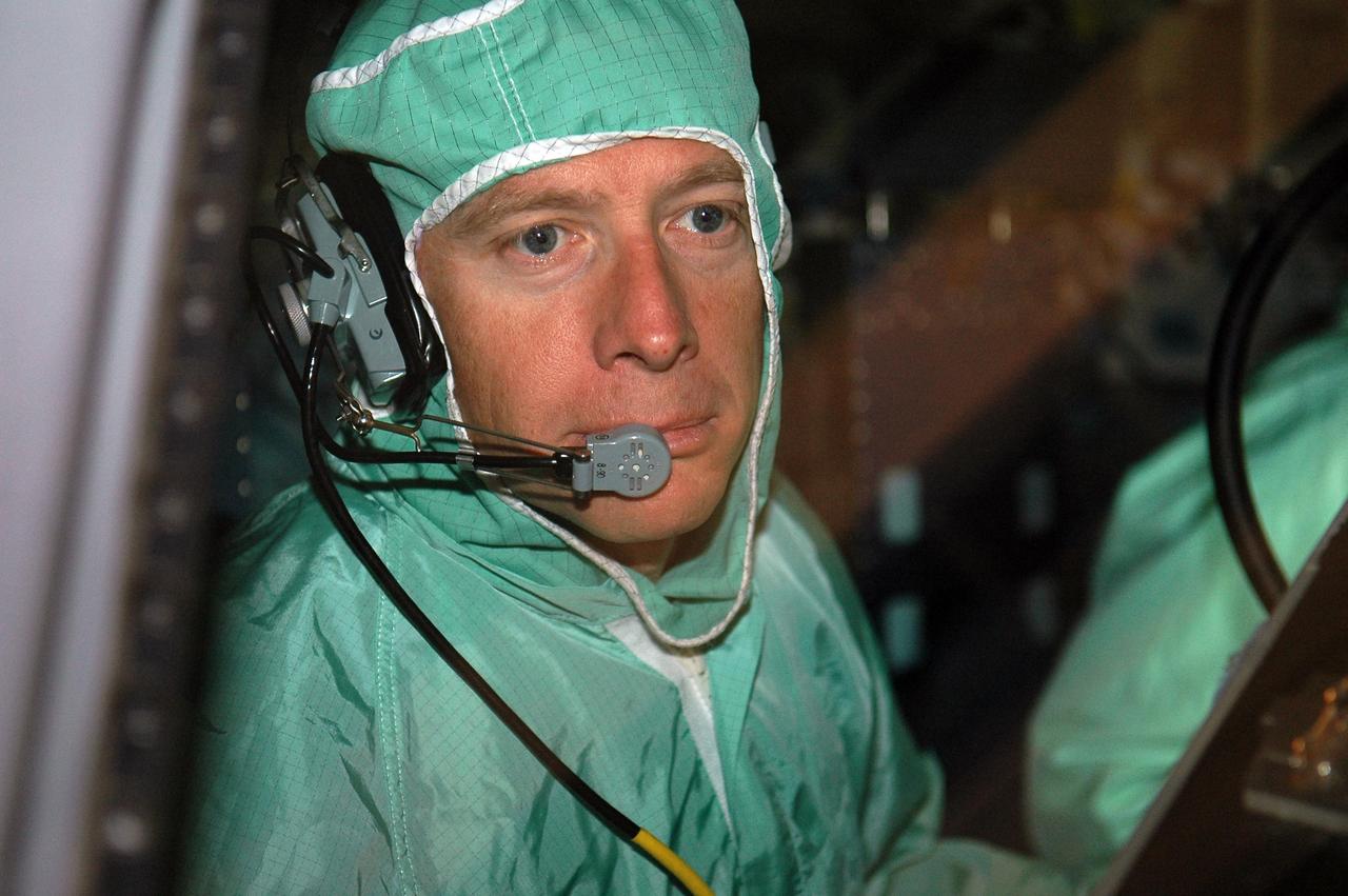 KENNEDY SPACE CENTER, FLA. -  In the Orbiter Processing Facility, STS-115 Pilot Christopher Ferguson inspects the window of the cockpit in the orbiter Atlantis.  The crew is at KSC for Crew Equipment Interface Test activities, which involve equipment familiarization and inspection, a routine part of astronaut training and launch preparations.  The STS-115 mission will deliver the second port truss segment, the P3/P4 truss, to the International Space Station.  The crew will attach the P3 to the first port truss segment, the P1 truss, as well as deploy solar array set 2A and 4A.  Launch on Space Shuttle Atlantis is scheduled for late August. Photo credit: NASA/Kim Shiflett