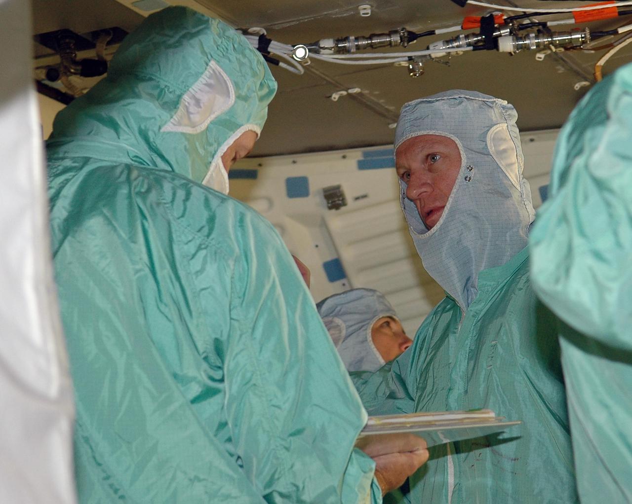 KENNEDY SPACE CENTER, FLA. -  In the Orbiter Processing Facility, STS-115 Commander Brent Jett continues inspection of the orbiter Atlantis with other crew members.  The crew is at KSC for Crew Equipment Interface Test activities, which involve equipment familiarization and inspection, a routine part of astronaut training and launch preparations.  The STS-115 mission will deliver the second port truss segment, the P3/P4 truss, to the International Space Station.  The crew will attach the P3 to the first port truss segment, the P1 truss, as well as deploy solar array set 2A and 4A.  Launch on Space Shuttle Atlantis is scheduled for late August. Photo credit: NASA/Kim Shiflett