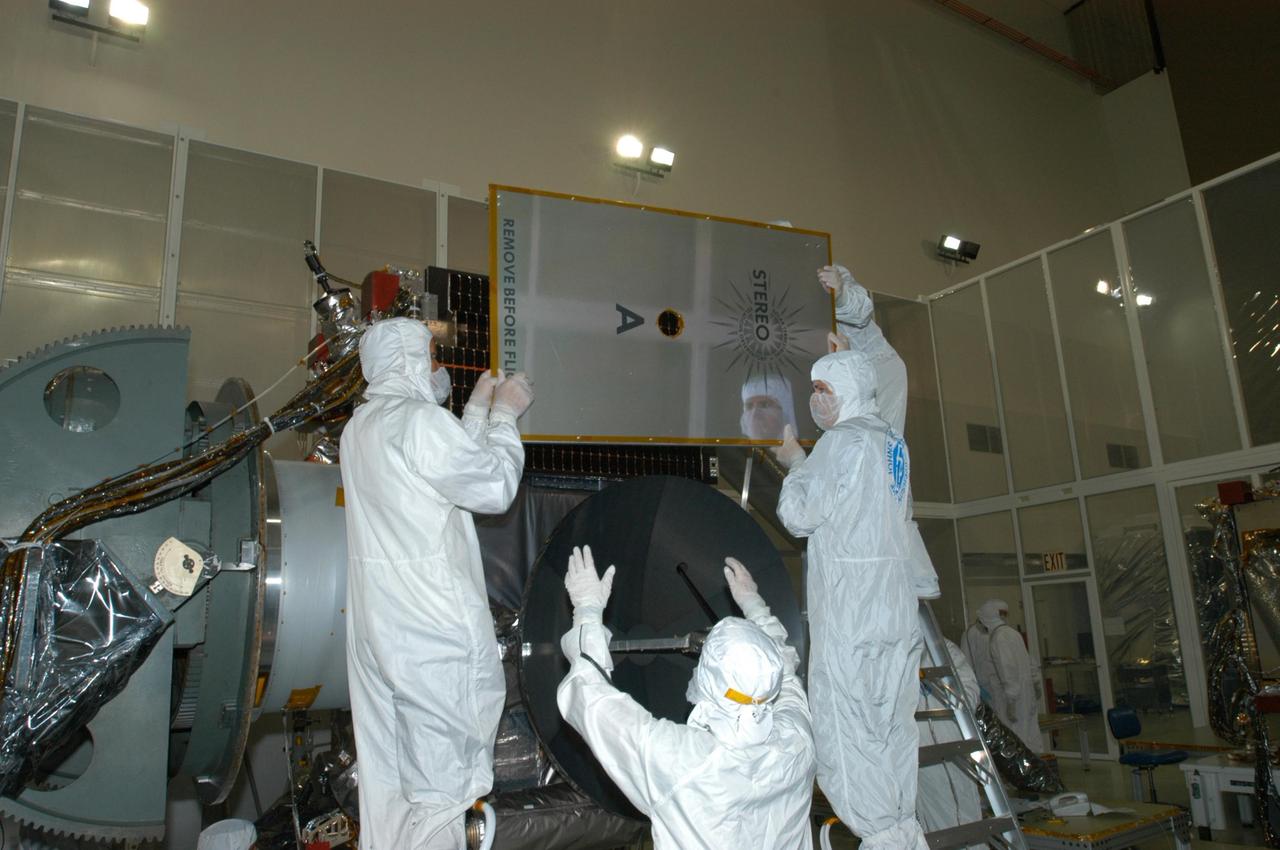KENNEDY SPACE CENTER, FLA. - At Astrotech Space Operations in Titusville, Fla., technicians remove the protective cover on the solar panel on the STEREO observatory "A" before deployment and testing. STEREO, which stands for Solar Terrestrial Relations Observatory, consists of two spacecraft whose mission is to take measurements of the sun and solar wind in 3-D, for the first time. This new view will improve our understanding of space weather and its impact on the Earth. Preparations are under way for a liftoff aboard a Delta rocket no earlier than July 30. Photo credit: NASA/George Shelton