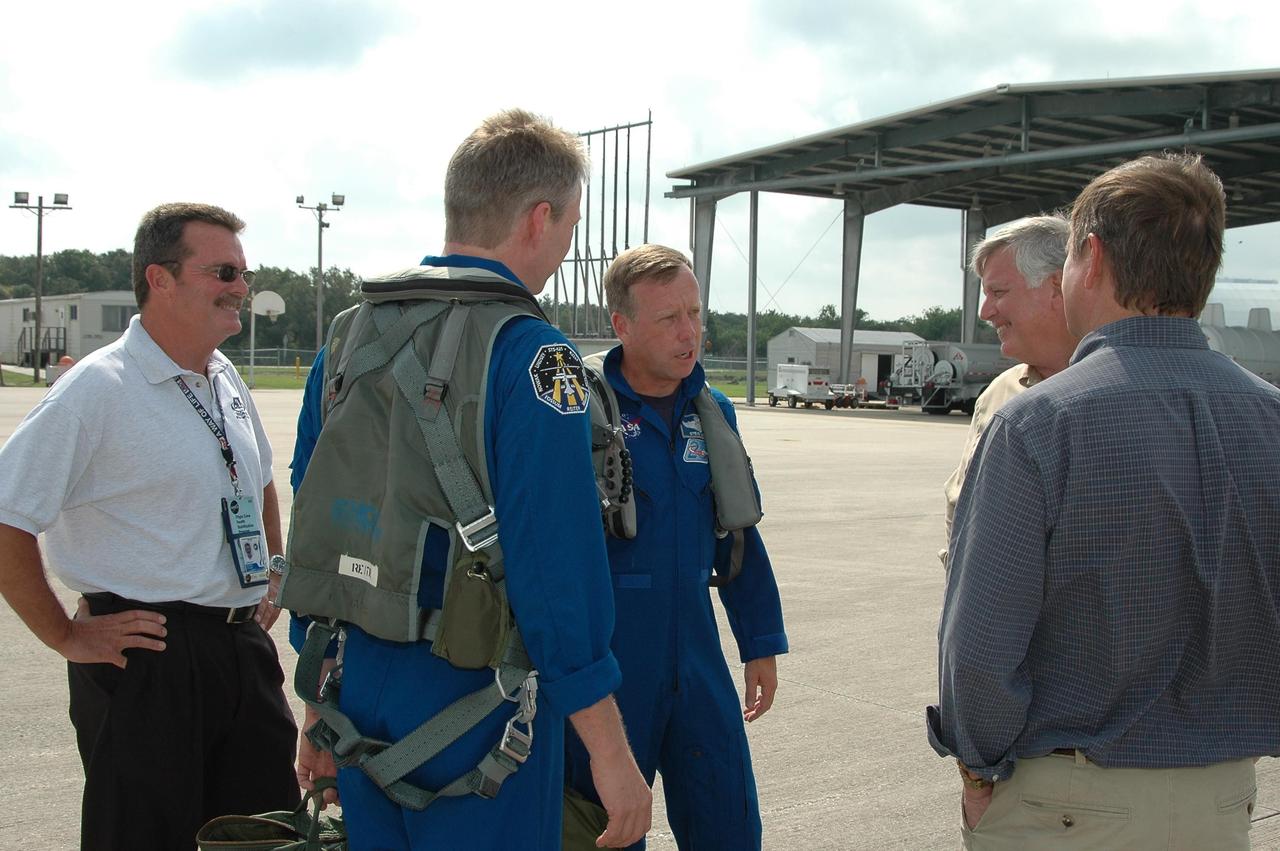 KENNEDY SPACE CENTER, FLA. -   After their arrival at the Shuttle Landing Facility to get ready for launch July 1, STS-121 Mission Specialist Thomas Reiter (second from left) and Commander Steven Lindsey are greeted (at right) by Center Director Jim Kennedy and Shuttle Launch Director Mike Leinbach.  During the 12-day mission, the STS-121 crew will test new equipment and procedures to improve shuttle safety, as well as deliver supplies and make repairs to the International Space Station. This mission is the 115th shuttle flight and the 18th U.S. flight to the International Space Station.  Photo credit: NASA/Kim Shiflett