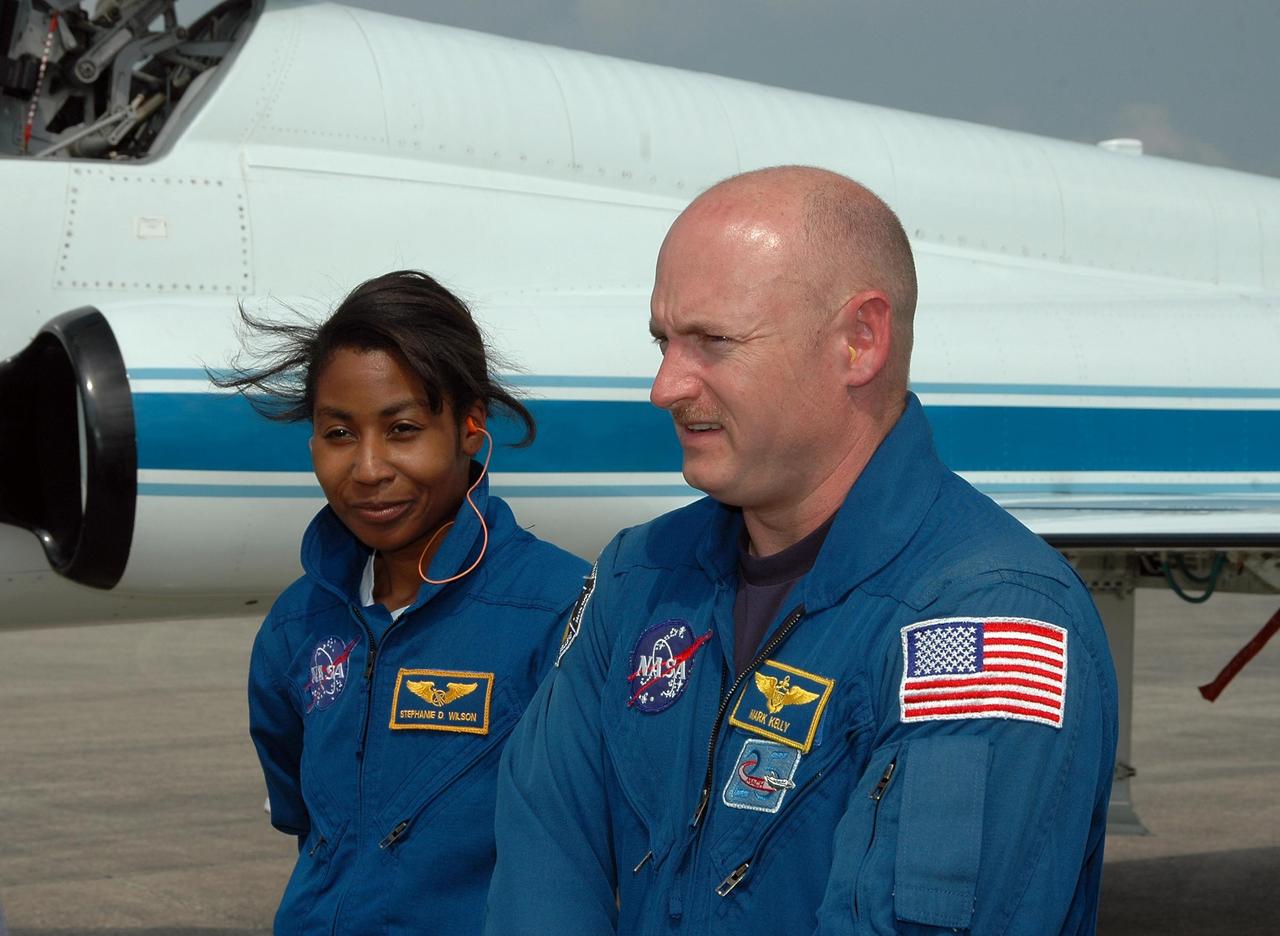 KENNEDY SPACE CENTER, FLA. - STS-121 Mission Specialist Stephanie Wilson and Pilot Mark Kelly walk across the Shuttle Landing Facility after their arrival to get ready for launch on July 1. The launch will be Wilson's first space flight. During the 12-day mission, the STS-121 crew will test new equipment and procedures to improve shuttle safety, as well as deliver supplies and make repairs to the International Space Station. This mission is the 115th shuttle flight and the 18th U.S. flight to the International Space Station. Photo credit: NASA/Kim Shiflett