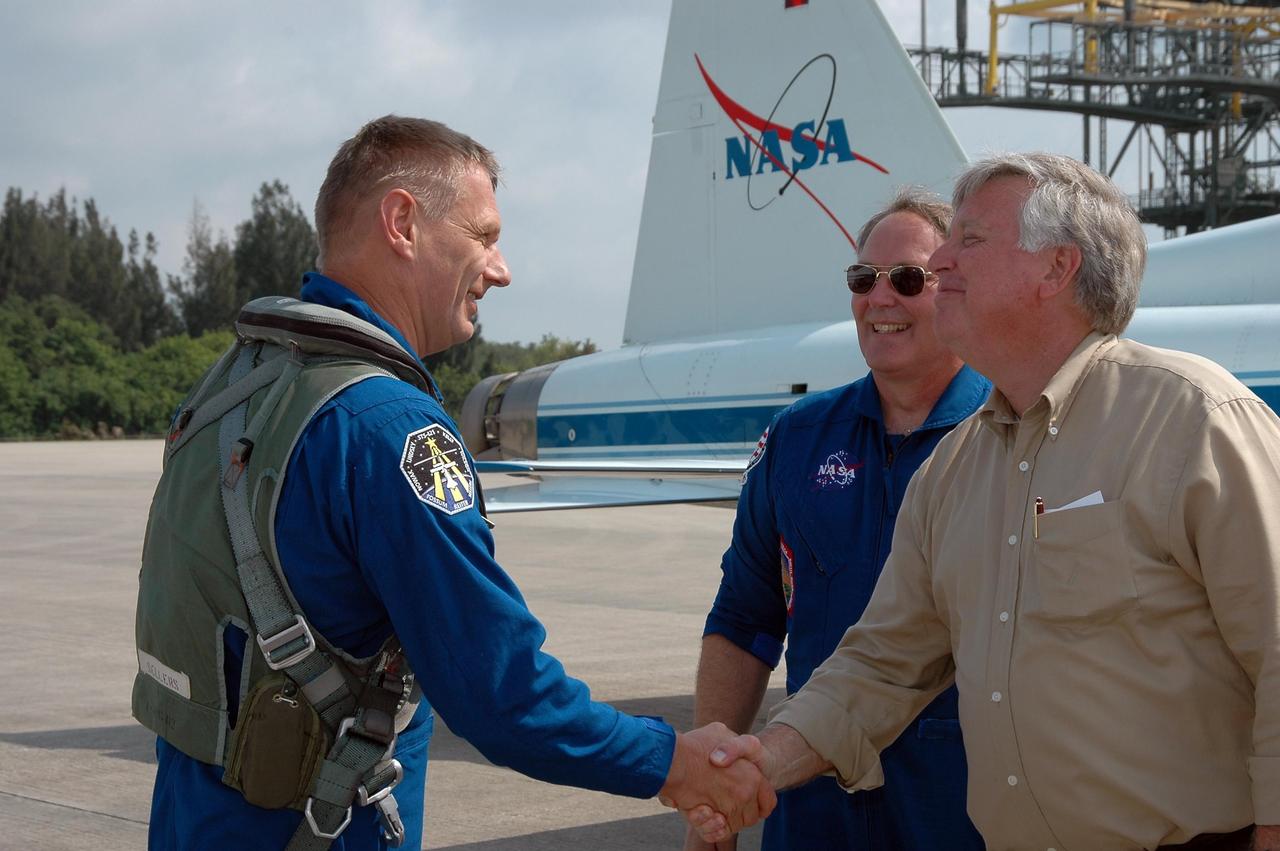 KENNEDY SPACE CENTER, FLA. - After his arrival at KSC, STS-121 Mission Specialist Piers Sellers is greeted by Center Director Jim Kennedy. Behind Kennedy is Jerry Ross, who is chief of the Vehicle Integration Test Office at Johnson Space Center. During the 12-day mission, the STS-121 crew will test new equipment and procedures to improve shuttle safety, as well as deliver supplies and make repairs to the International Space Station. This mission is the 115th shuttle flight and the 18th U.S. flight to the International Space Station. Photo credit: NASA/Kim Shiflett
