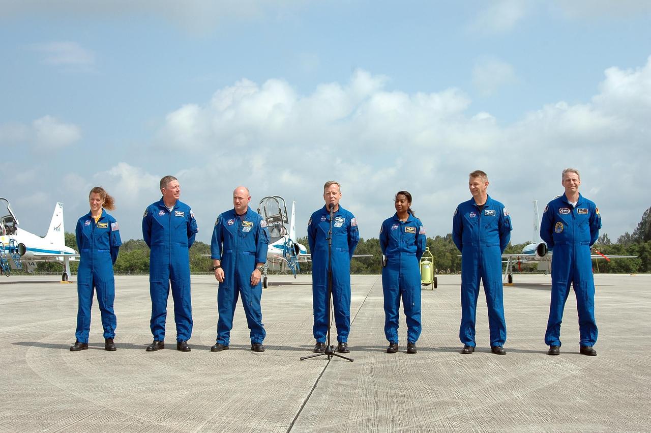 KENNEDY SPACE CENTER, FLA. -   After their arrival at KSC to prepare for launch on July 1, the STS-121 crew greets the media on the Shuttle Landing Facility.  From left are Mission Specialists Lisa Nowak and Michael Fossum, Pilot Mark Kelly, Commander Steven Lindsey, and Mission Specialists Stephanie Wilson, Piers Sellers and Thomas Reiter.  During the 12-day mission, the STS-121 crew will test new equipment and procedures to improve shuttle safety, as well as deliver supplies and make repairs to the International Space Station. This mission is the 115th shuttle flight and the 18th U.S. flight to the International Space Station.  Photo credit: NASA/Kim Shiflett