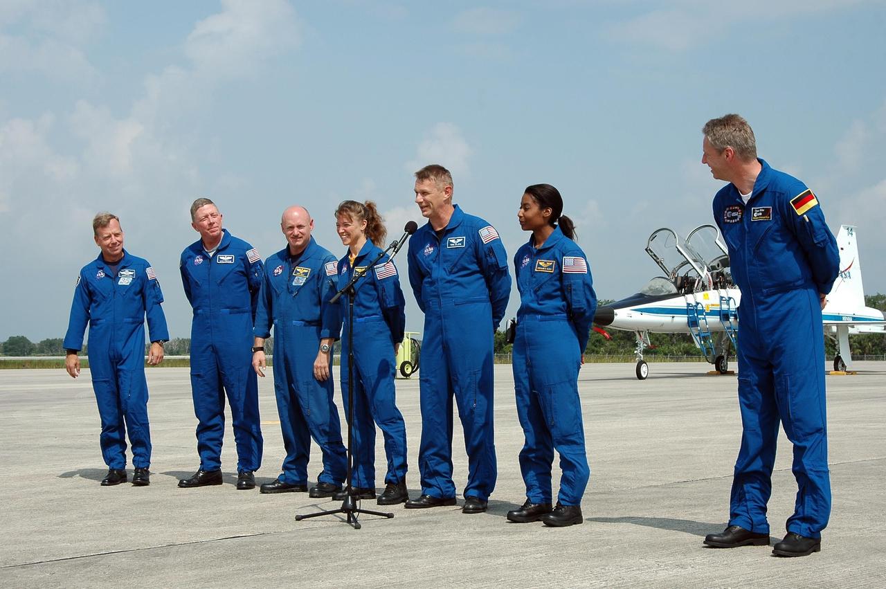 KENNEDY SPACE CENTER, FLA. -  After their arrival at KSC to prepare for launch on July 1, the STS-121 crew greets the media on the Shuttle Landing Facility.  At the microphone is Mission Specialist Piers Sellers.  From left are Commander Steven Lindsey, Mission Specialist Michael Fossum, Pilot Mark Kelly, and Mission Specialists Lisa Nowak, Sellers, Stephanie Wilson and Thomas Reiter.  During the 12-day mission, the STS-121 crew will test new equipment and procedures to improve shuttle safety, as well as deliver supplies and make repairs to the International Space Station. This mission is the 115th shuttle flight and the 18th U.S. flight to the International Space Station.  Photo credit: NASA/Kim Shiflett