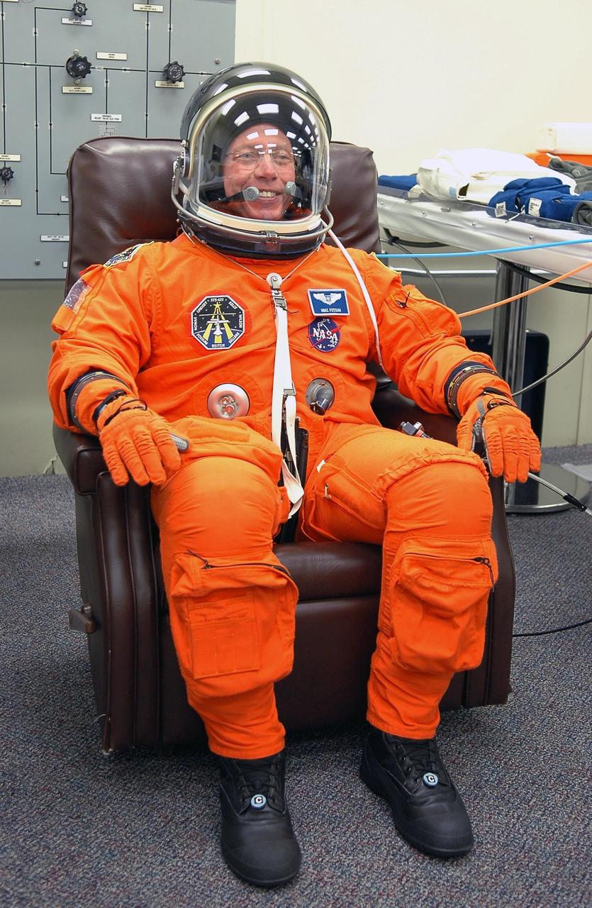 KENNEDY SPACE CENTER, FLA. - STS-121 Mission Specialist Michael Fossum completes the fitting of his launch suit in the Operations and Checkout Building. On the 12-day mission, the crew will test new equipment and procedures to improve shuttle safety, as well as deliver supplies and make repairs to the station. This mission is the 115th shuttle flight and the 18th U.S. flight to the station. Photo credit: NASA/Kim Shiflett