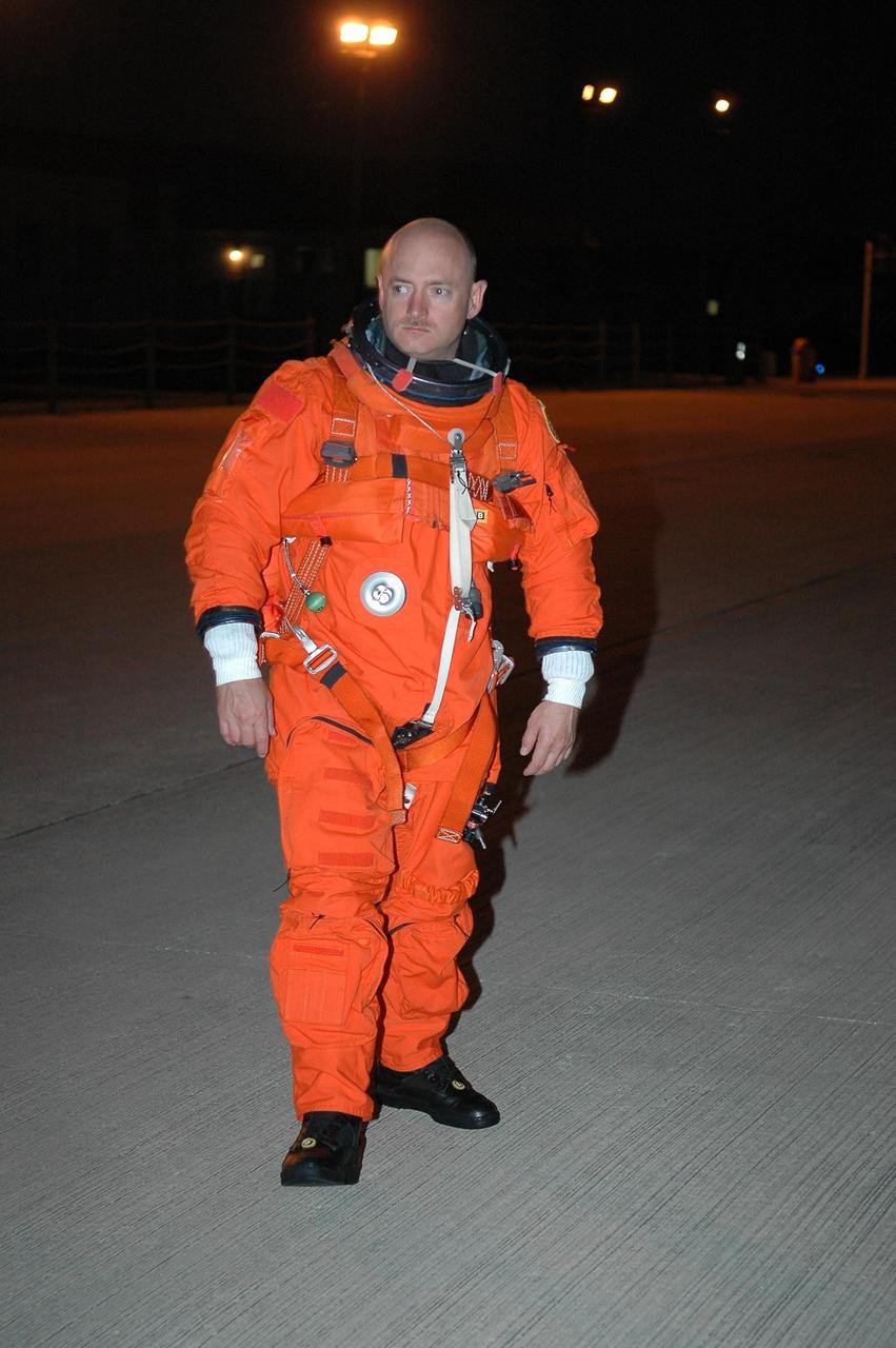 KENNEDY SPACE CENTER, FLA. -   In the pre-dawn hours, STS-121 Pilot Mark Kelly heads across the Shuttle Landing Facility to the Shuttle Training Aircraft (STA).  Kelly and Commander Steven Lindsey will be making practice landings in preparation for the July 1 launch of Space Shuttle Discovery.  The STA is a Grumman American Aviation-built Gulf Stream II jet that was modified to simulate an orbiter’s cockpit, motion and visual cues, and handling qualities. In flight, the STA duplicates the orbiter’s atmospheric descent trajectory from approximately 35,000 feet altitude to landing on a runway. Because the orbiter is unpowered during re-entry and landing, its high-speed glide must be perfectly executed the first time.  Photo credit: NASA/Kim Shiflett