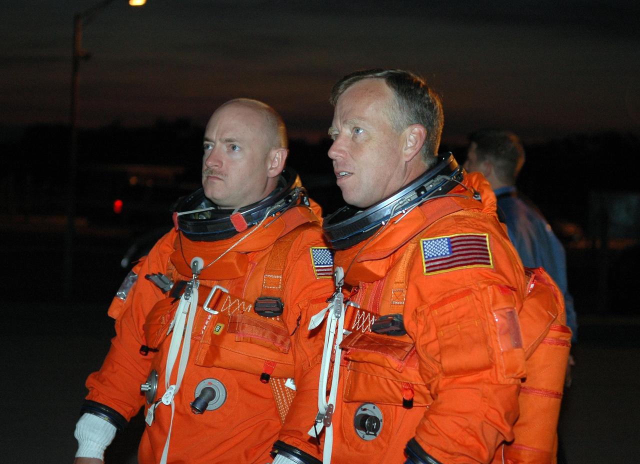 KENNEDY SPACE CENTER, FLA. -    In the pre-dawn hours, STS-121 Pilot Mark Kelly (left) and Commander Steven Lindsey look at the Shuttle Training Aircraft (STA) they will be flying to practice landings in preparation for the July 1 launch of Space Shuttle Discovery.   The STA is a Grumman American Aviation-built Gulf Stream II jet that was modified to simulate an orbiter’s cockpit, motion and visual cues, and handling qualities. In flight, the STA duplicates the orbiter’s atmospheric descent trajectory from approximately 35,000 feet altitude to landing on a runway. Because the orbiter is unpowered during re-entry and landing, its high-speed glide must be perfectly executed the first time.  Photo credit: NASA/Kim Shiflett