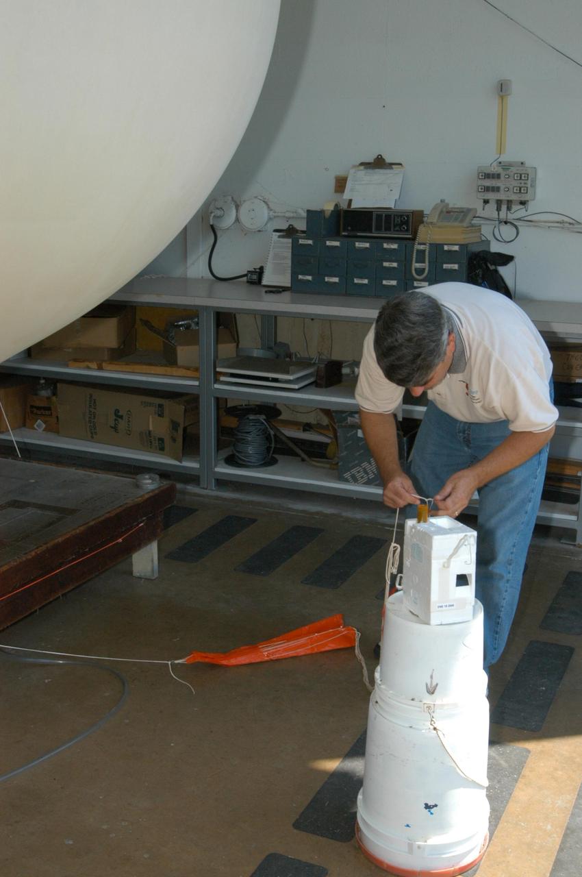 KENNEDY SPACE CENTER, FLA. -   At the Cape Canaveral weather station in Florida, a member of the weather team prepares a Rawinsonde weather balloon for release.  The release was planned as part of a media tour prior to the launch of Space Shuttle Discovery on mission STS-121 July 1. At the facility, which is operated by the U.S. Air Force 45th Weather Squadron, media saw the tools used by the weather team to create the forecast for launch day. They received a briefing on how the launch weather forecast is developed by Shuttle Weather Officer Kathy Winters and met the forecasters for the space shuttle and the expendable launch vehicles. Also participating were members of the Applied Meteorology Unit who provide special expertise to the forecasters by analyzing and interpreting unusual or inconsistent weather data. The media were able to see the release of the Rawinsonde weather balloon carrying instruments aloft to be used as part of developing the forecast.  Photo credit: NASA/George Shelton
