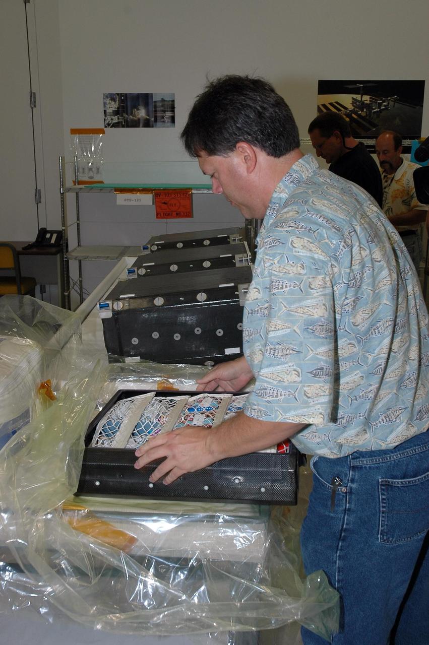 KENNEDY SPACE CENTER, FLA. -  In the Space Station Processing Facility at NASA's Kennedy Space Center,  John Hoog packs up food containers with the meals prepared for the crew of mission STS-121.  Hoog is a USA-FCE/EVA representative from Johnson Space Center.  Astronauts select their own menus from a large array of food items. Astronauts are supplied with three balanced meals, plus snacks.  Foods flown on space missions are researched and developed at the Space Food Systems Laboratory at the Johnson Space Center (JSC) in Houston, which is staffed by food scientists, dietitians and engineers. Foods are analyzed through nutritional analysis, sensory evaluation, storage studies, packaging evaluations and many other methods.   Each astronaut’s food is stored aboard the space shuttle and is identified by a colored dot affixed to each package.  Launch of Space Shuttle Discovery on mission STS-121 is scheduled for July 1.  Photo credit: NASA/Jack Pfaller
