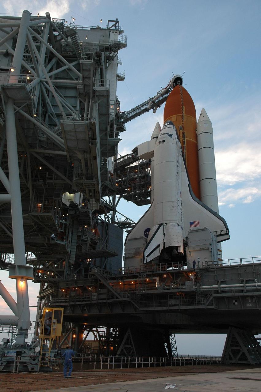 KENNEDY SPACE CENTER, FLA. - In preparation for the July 1 launch of Space Shuttle Discovery on mission STS-121, the Launch Pad 39B rotating service structure (RSS) enclosing the shuttle rolls away. Above the golden external tank is the vent hood (known as the "beanie cap") at the end of the gaseous oxygen vent arm. Vapors are created as the liquid oxygen in the external tank boil off. The hood vents the gaseous oxygen vapors away from the space shuttle vehicle. The RSS provides protected access to the orbiter for changeout and servicing of payloads at the pad. The structure is supported by a rotating bridge that pivots about a vertical axis on the west side of the pad's flame trench. The hinge column rests on the pad surface and is braced to the fixed service structure. Support for the outer end of the bridge is provided by two eight-wheel, motor-driven trucks that move along circular twin rails installed flush with the pad surface. The track crosses the flame trench on a permanent bridge. The RSS is 102 feet long, 50 feet wide and 130 feet high. The structure has orbiter access platforms at five levels to provide access to the payload bay while the orbiter is being serviced in the RSS. Each platform has independent extendable planks that can be arranged to conform to a payload's configuration. This mission is the 115th shuttle flight and the 18th U.S. flight to the International Space Station. Photo credit: NASA/Kim Shiflett
