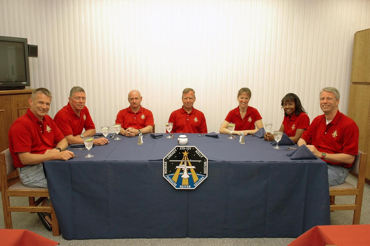 KENNEDY SPACE CENTER, FLA. -   The mission STS-121 crew gathers for the traditional breakfast before they suit up for launch.  Seated left to right are Mission Specialists Piers Sellers and Michael Fossum, Pilot Mark Kelly, Commander Steven Lindsey, and Mission Specialists Lisa Nowak, Stephanie Wilson and Thomas Reiter, who represents the European Space Agency.  The launch of Space Shuttle Discovery on mission STS-121 is the 115th shuttle flight and the 18th U.S. flight to the International Space Station.  During the 12-day mission, the STS-121 crew will test new equipment and procedures to improve shuttle safety, as well as deliver supplies and make repairs to the International Space Station. Photo credit: NASA/Kim Shiflett