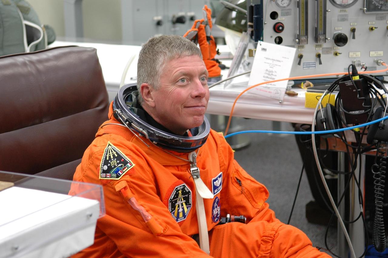 KENNEDY SPACE CENTER, FLA. -   The STS-121 crew are donning their orange launch and entry suits for launch today on Space Shuttle Discovery.  Seated here is Mission Specialist Michael Fossum, who is making his first space flight. The launch is the 115th shuttle flight and the 18th U.S. flight to the International Space Station.  During the 12-day mission, the STS-121 crew will test new equipment and procedures to improve shuttle safety, as well as deliver supplies and make repairs to the International Space Station.  Photo credit: NASA/Kim Shiflett