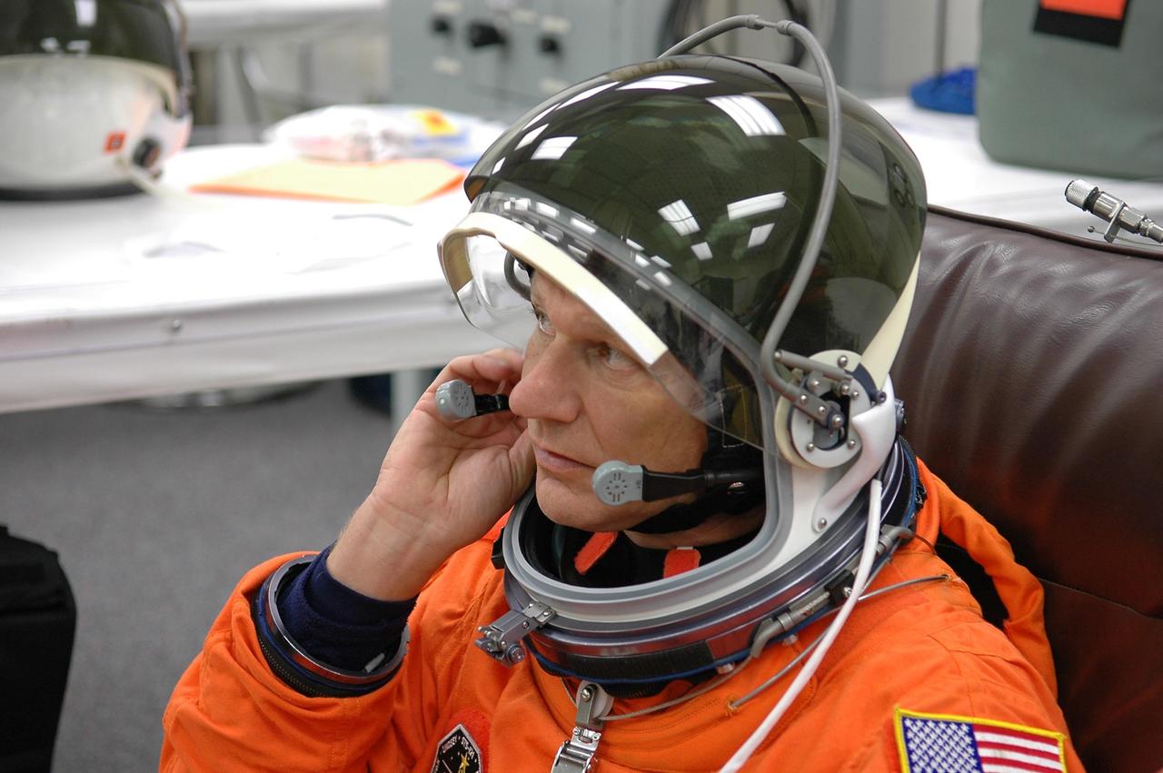 KENNEDY SPACE CENTER, FLA. -     The STS-121 crew are donning their orange launch and entry suits for launch today on Space Shuttle Discovery.  Here, Mission Specialist Piers Sellers adjusts part of his helmet.  Sellers is making his second space flight.  The launch is the 115th shuttle flight and the 18th U.S. flight to the International Space Station.  During the 12-day mission, the STS-121 crew will test new equipment and procedures to improve shuttle safety, as well as deliver supplies and make repairs to the International Space Station.  Photo credit: NASA/Kim Shiflett
