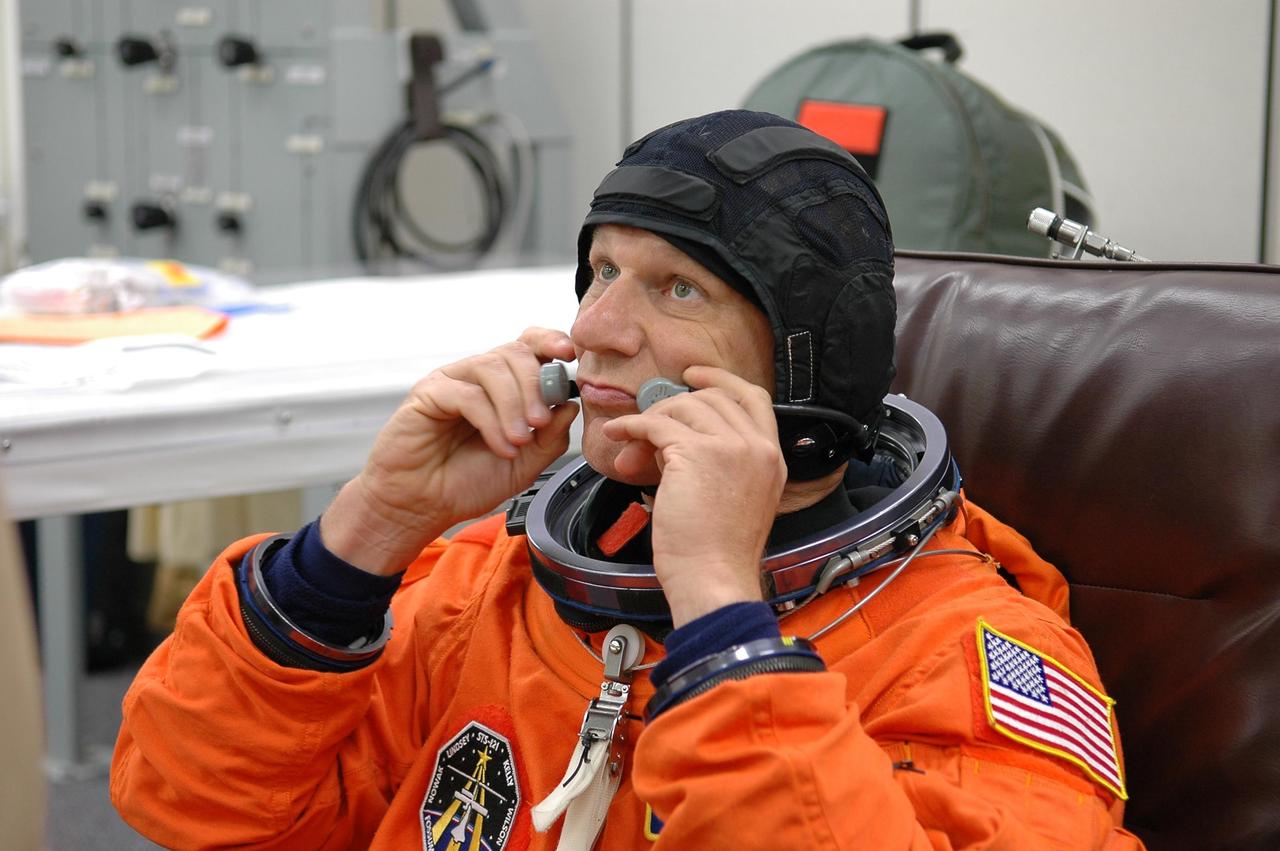 KENNEDY SPACE CENTER, FLA. -  During suitup for launch today on Space Shuttle Discovery, STS-121 Mission Specialist Piers Sellers adjusts the communication device worn under his helmet.    The launch is the 115th shuttle flight and the 18th U.S. flight to the International Space Station.  During the 12-day mission, the STS-121 crew will test new equipment and procedures to improve shuttle safety, as well as deliver supplies and make repairs to the International Space Station.  Photo credit: NASA/Kim Shiflett