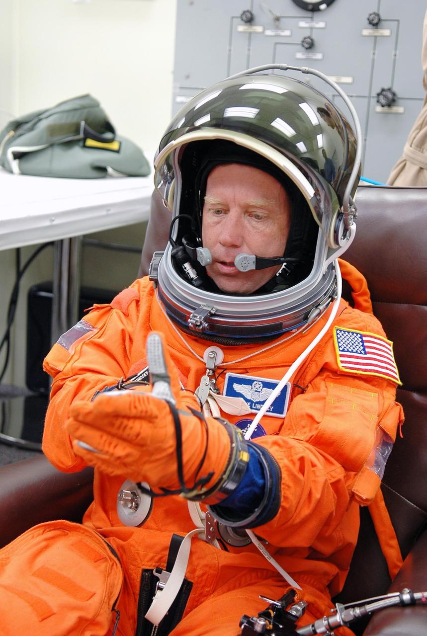 KENNEDY SPACE CENTER, FLA. -   STS-121 Commander Steven Lindsey adjusts his glove as he dons his launch and entry suit for launch today on Space Shuttle Discovery.  Lindsey is making his fourth space flight.  The launch is the 115th shuttle flight and the 18th U.S. flight to the International Space Station.  During the 12-day mission, the STS-121 crew will test new equipment and procedures to improve shuttle safety, as well as deliver supplies and make repairs to the International Space Station.  Photo credit: NASA/Kim Shiflett