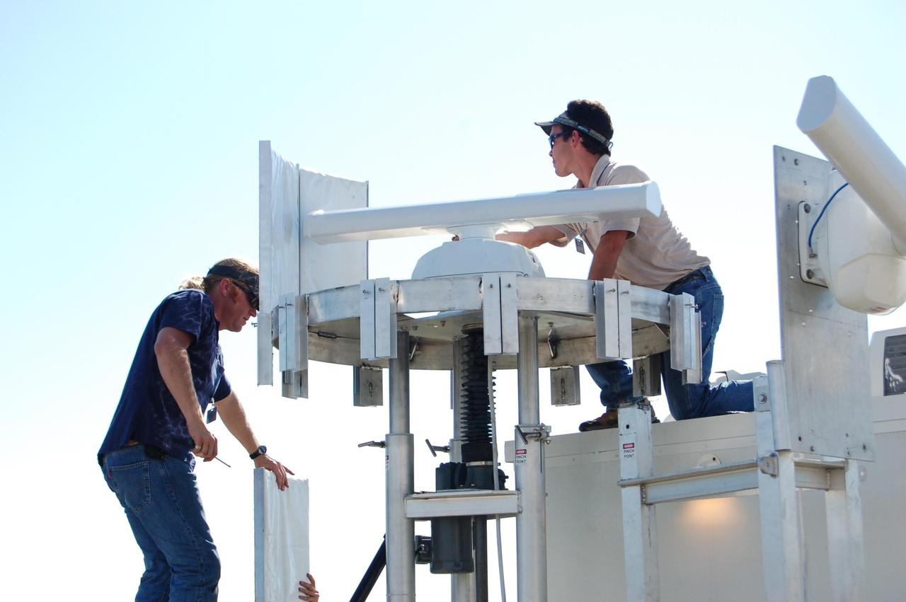 KENNEDY SPACE CENTER, FLA. - Radar technicians set up bird detection radar near Launch Pad 39B before the July 1 launch of Space Shuttle Discovery on mission STS-121. When birds, especially vultures, are near the shuttle during a launch, impact on a critical area is possible and could cause catastrophic damage to the vehicle. Already proven affective for aviation where threats posed by bird strikes have been a problem, the avian radar, known as Aircraft Birdstrike Avoidance Radar, provides horizontal and vertical scanning and can monitor either launch pad for movement of vultures around them. If data relayed from the avian radar indicates large birds are dangerously close to the vehicle, controllers could hold the countdown. Photo credit: NASA/Gianni Woods