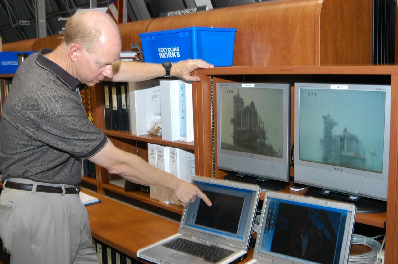 KENNEDY SPACE CENTER, FLA. - In Firing Room 4 of the Launch Control Center, NASA Test Director Steve Payne points to laptop computers that will display data relayed from the avian radars recently set up on Launch Pad 39B. When birds, especially vultures, are near the shuttle during a launch, impact on a critical area is possible and could cause catastrophic damage to the vehicle. Already proven affective for aviation where threats posed by bird strikes have been a problem, the avian radar, known as Aircraft Birdstrike Avoidance Radar, provides horizontal and vertical scanning and can monitor either launch pad for movement of vultures around them. If data relayed from the avian radar indicates large birds are dangerously close to the vehicle, controllers could hold the countdown. Photo credit: NASA/George Shelton