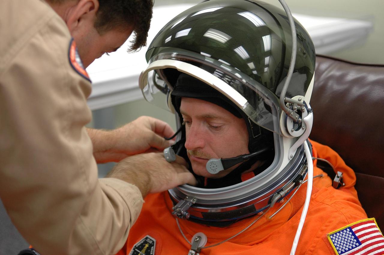 KENNEDY SPACE CENTER, FLA. -  STS-121 Pilot Mark Kelly gets help with his helmet fitting during suitup for a second launch attempt on Space Shuttle Discovery.  The first launch attempt July 1 was scrubbed due to weather concerns and postponed 24 hours.  The launch is the 115th shuttle flight and the 18th U.S. flight to the International Space Station.  During the 12-day mission, the STS-121 crew will test new equipment and procedures to improve shuttle safety, as well as deliver supplies and make repairs to the International Space Station. Photo credit: NASA/Kim Shiflett