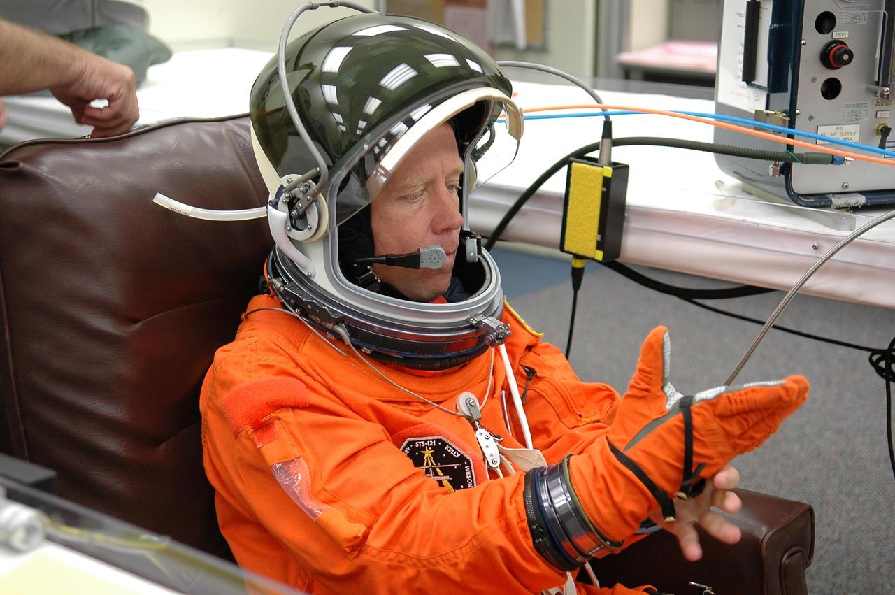 KENNEDY SPACE CENTER, FLA. -   STS-121 Commander Steven Lindsey pulls on his glove during suitup for a second launch attempt on Space Shuttle Discovery.  The first launch attempt July 1 was scrubbed due to weather concerns and postponed 24 hours.   The launch is the 115th shuttle flight and the 18th U.S. flight to the International Space Station.  During the 12-day mission, the STS-121 crew will test new equipment and procedures to improve shuttle safety, as well as deliver supplies and make repairs to the International Space Station. Photo credit: NASA/Kim Shiflett