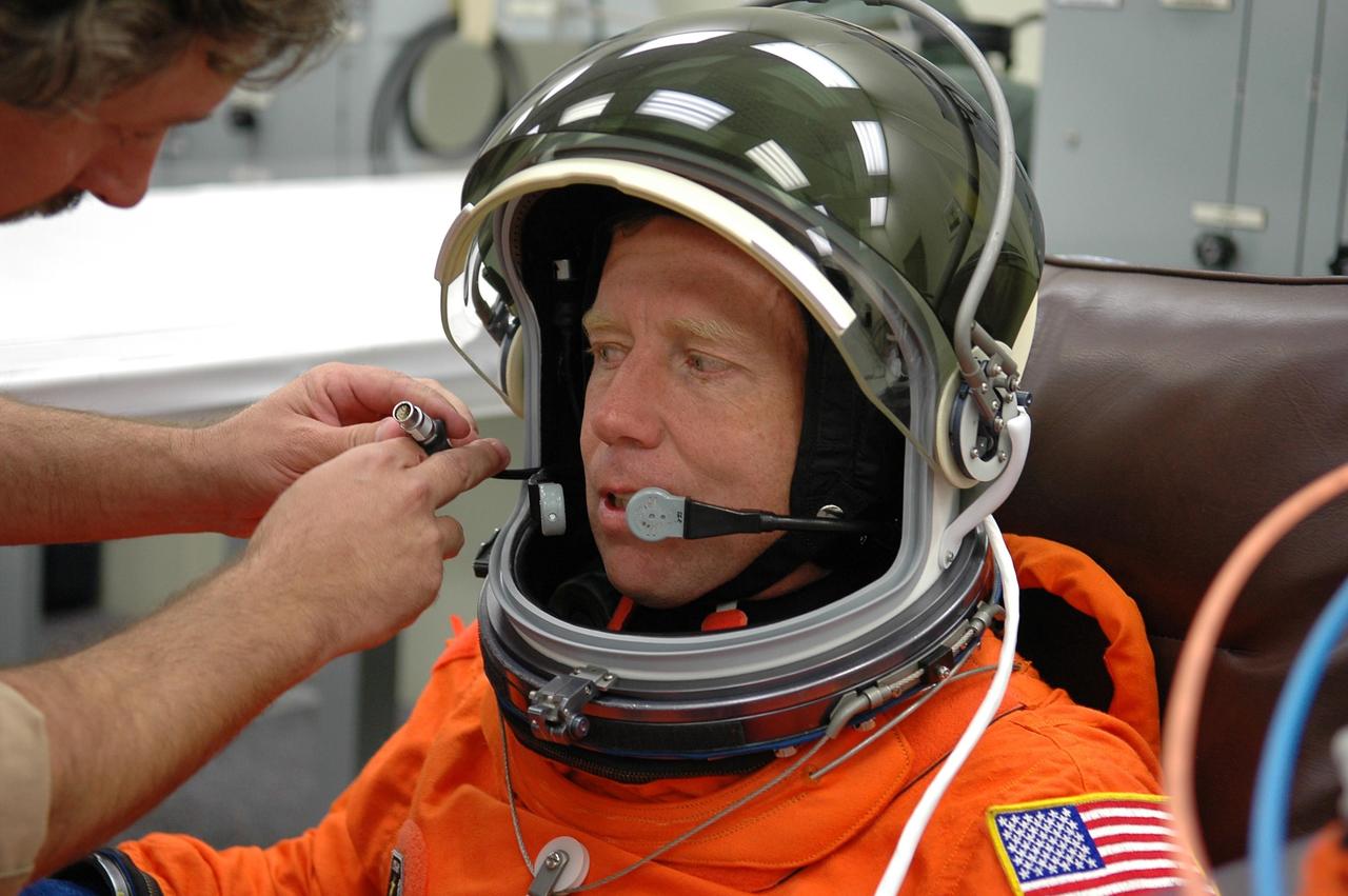 KENNEDY SPACE CENTER, FLA. -   STS-121 Commander Steven Lindsey is helped with his helmet during  suitup for a second launch attempt on Space Shuttle Discovery.  The first launch attempt July 1 was scrubbed due to weather concerns and postponed 24 hours. The launch of Space Shuttle Discovery on mission STS-121 is the 115th shuttle flight and the 18th U.S. flight to the International Space Station.  During the 12-day mission, the STS-121 crew will test new equipment and procedures to improve shuttle safety, as well as deliver supplies and make repairs to the International Space Station.  Photo credit: NASA/Kim Shiflett