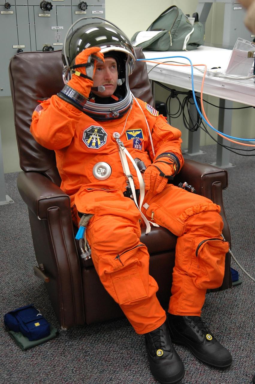 KENNEDY SPACE CENTER, FLA. -   STS-121 Pilot Mark Kelly  adjusts his helmet during suitup for a second launch attempt on Space Shuttle Discovery.  The first launch attempt July 1 was scrubbed due to weather concerns and postponed 24 hours.  The launch is the 115th shuttle flight and the 18th U.S. flight to the International Space Station.  During the 12-day mission, the STS-121 crew will test new equipment and procedures to improve shuttle safety, as well as deliver supplies and make repairs to the International Space Station. Photo credit: NASA/Kim Shiflett