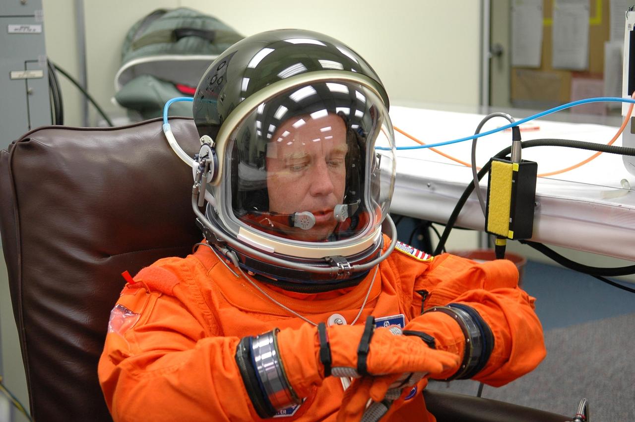 KENNEDY SPACE CENTER, FLA. -   STS-121 Commander Steven Lindsey adjusts a glove during suitup for a second launch attempt on Space Shuttle Discovery.  The first launch attempt July 1 was scrubbed due to weather concerns and postponed 24 hours.  The launch is the 115th shuttle flight and the 18th U.S. flight to the International Space Station.  During the 12-day mission, the STS-121 crew will test new equipment and procedures to improve shuttle safety, as well as deliver supplies and make repairs to the International Space Station. Photo credit: NASA/Kim Shiflett
