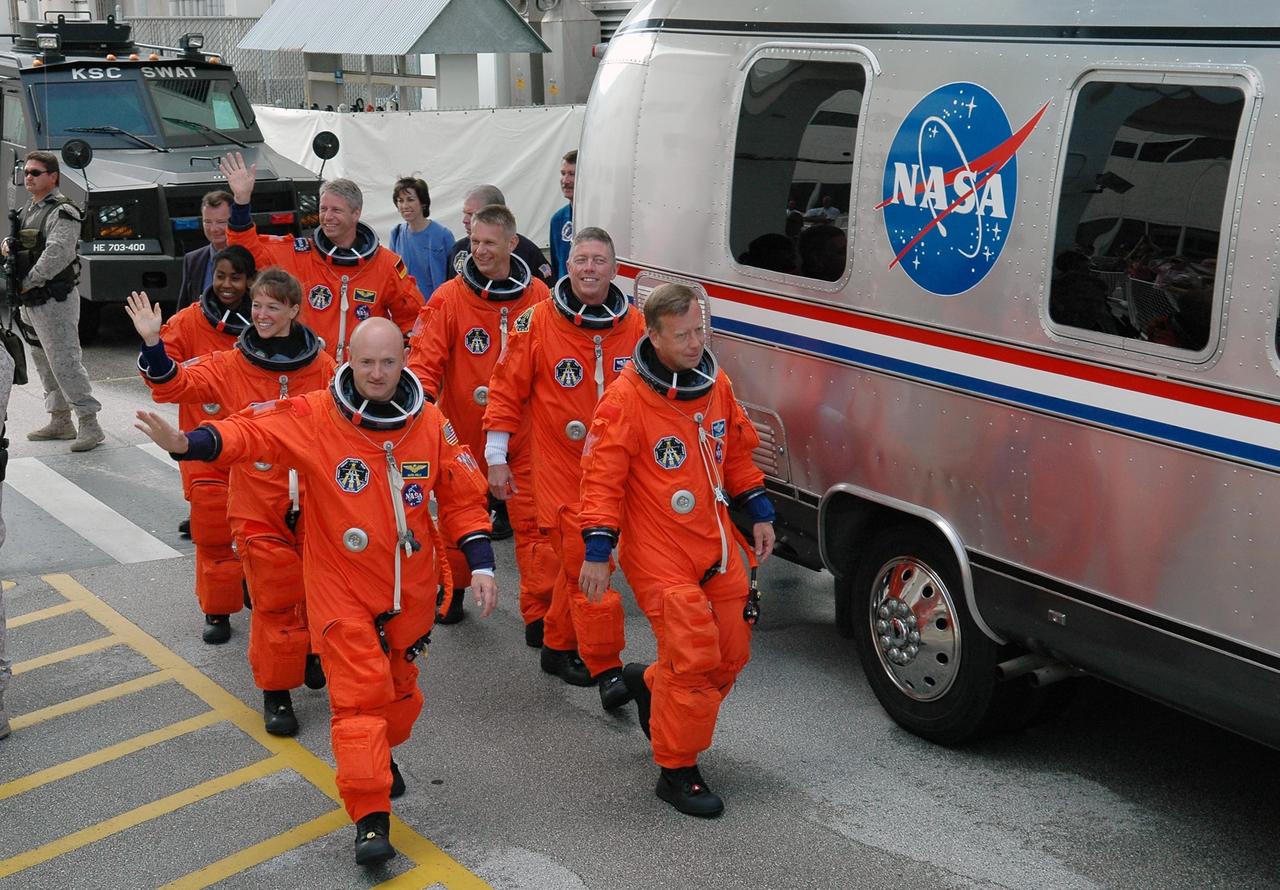 KENNEDY SPACE CENTER, FLA. -   For the second time in two days, the STS-121 crew heads for the Astrovan to take them to Launch Pad 39B and launch of Space Shuttle Discovery.  On the left side, from left, are Mission Specialists Stephanie Wilson and Lisa Nowak, and Pilot Mark Kelly.  On the right side, left to right, are Mission Specialists Thomas Reiter, Piers Sellers and Michael Fossum, and Commander Steven Lindsey.  The first launch attempt July 1 was scrubbed due to weather concerns and postponed 24 hours.  The launch is the 115th shuttle flight and the 18th U.S. flight to the International Space Station.  During the 12-day mission, the STS-121 crew will test new equipment and procedures to improve shuttle safety, as well as deliver supplies and make repairs to the International Space Station. Photo credit: NASA/Kim Shiflett