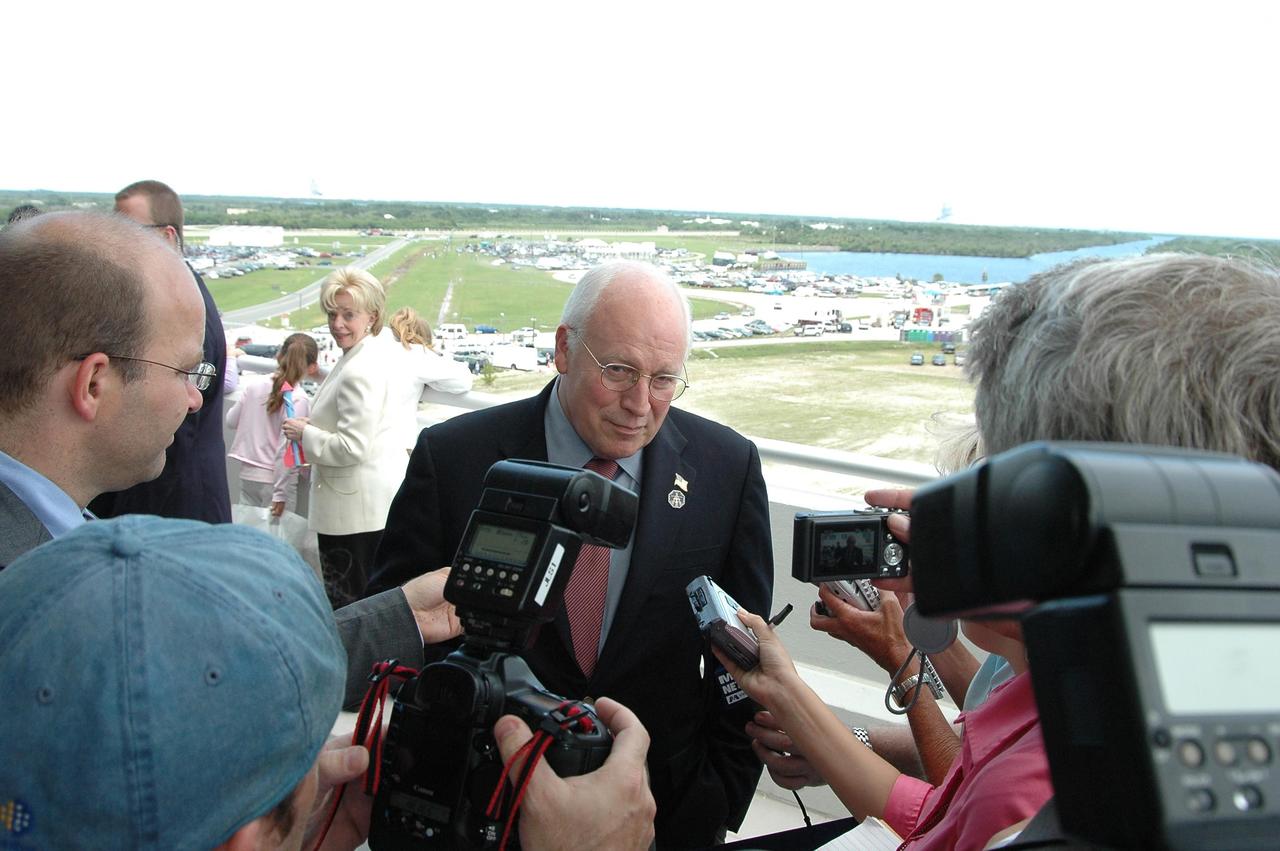 KENNEDY SPACE CENTER, FLA. - U.S. Vice President Dick Cheney talks to the media on the observation deck of the Operations and Support Building II at NASA's Kennedy Space Center. In the background, the white jacket, is Cheney's wife, Lynne. Cheney is at the Center to view the launch of Space Shuttle Discovery on mission STS-121. Photo credit: NASA/Kim Shiflett