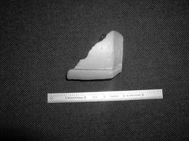 KENNEDY SPACE CENTER, FLA. - A piece of insulation - three inches long, one-eighth to one-quarter inch wide and weighing approximately 0.0057 pounds - was liberated from a strut that attaches the liquid oxygen feedline to External Tank-119.  The tank is being used to launch space shuttle mission STS-121.  It was recovered by the Ice Team from the mobile launch platform at Pad 39B.  It is believed that the rain experienced during yesterday’s launch attempt of Discovery caused water to run down the feedline and form ice near the strut next to the feedline bracket.  As the tank warmed and expanded, the ice that formed most likely pinched the foam on the top of the strut, causing a crack and eventual loss of the small piece of foam. Photo credit: NASA