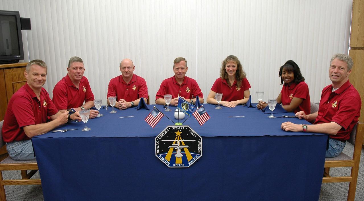 KENNEDY SPACE CENTER, FLA. - Trying a third time for launch, and still smiling, the STS-121 crew gathers again for the traditional breakfast before suiting up. Seated left to right are Mission Specialists Piers Sellers and Michael Fossum, Pilot Mark Kelly, Commander Steven Lindsey, and Mission Specialists Lisa Nowak, Stephanie Wilson and Thomas Reiter, who represents the European Space Agency. The July 2 launch attempt was scrubbed due to the presence of showers and thunderstorms within the surrounding area of the launch site. The launch of Space Shuttle Discovery on mission STS-121 is the 115th shuttle flight and the 18th U.S. flight to the International Space Station. During the 12-day mission, the STS-121 crew will test new equipment and procedures to improve shuttle safety, as well as deliver supplies and make repairs to the International Space Station. Photo credit: NASA/Kim Shiflett