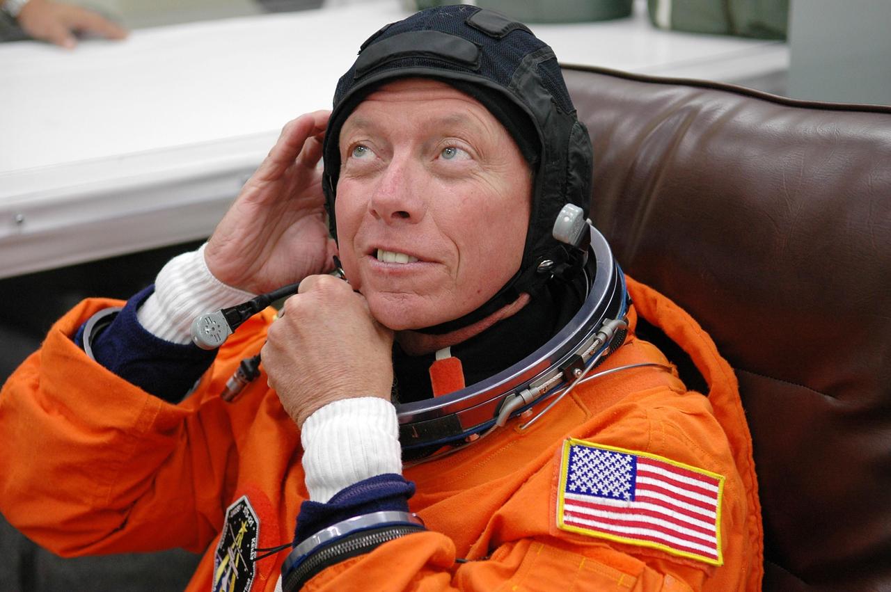 KENNEDY SPACE CENTER, FLA. -   Prior to the third launch attempt on mission STS-121, Mission Specialist Michael Fossum adjusts part of his launch suit before heading to Launch Pad 39B.  The launch of Space Shuttle Discovery on mission STS-121 is the 115th shuttle flight and the 18th U.S. flight to the International Space Station.  During the 12-day mission, the STS-121 crew will test new equipment and procedures to improve shuttle safety, as well as deliver supplies and make repairs to the International Space Station.  Photo credit: NASA/Kim Shiflett