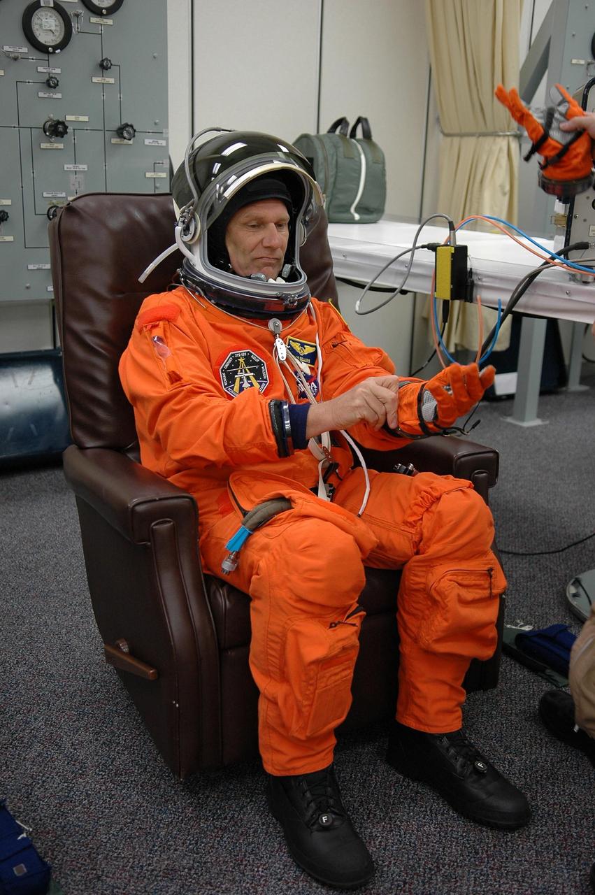 KENNEDY SPACE CENTER, FLA. -   Mission Specialist Piers Sellers adjusts his glove while donning his launch suit before heading to Launch Pad 39B and liftoff on mission STS-121.  The launch of Space Shuttle Discovery on mission STS-121 is the 115th shuttle flight and the 18th U.S. flight to the International Space Station.  During the 12-day mission, the STS-121 crew will test new equipment and procedures to improve shuttle safety, as well as deliver supplies and make repairs to the International Space Station.  Photo credit: NASA/Kim Shiflett