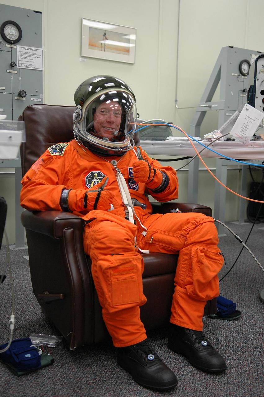 KENNEDY SPACE CENTER, FLA. - After suiting up in his launch suit, Mission Specialist Michael Fossum gives a thumbs up for a third launch attempt on mission STS-121. The July 2 launch attempt was scrubbed due to the presence of showers and thunderstorms within the surrounding area of the launch site. The launch of Space Shuttle Discovery on mission STS-121 is the 115th shuttle flight and the 18th U.S. flight to the International Space Station. During the 12-day mission, the STS-121 crew will test new equipment and procedures to improve shuttle safety, as well as deliver supplies and make repairs to the International Space Station. Photo credit: NASA/Kim Shiflett