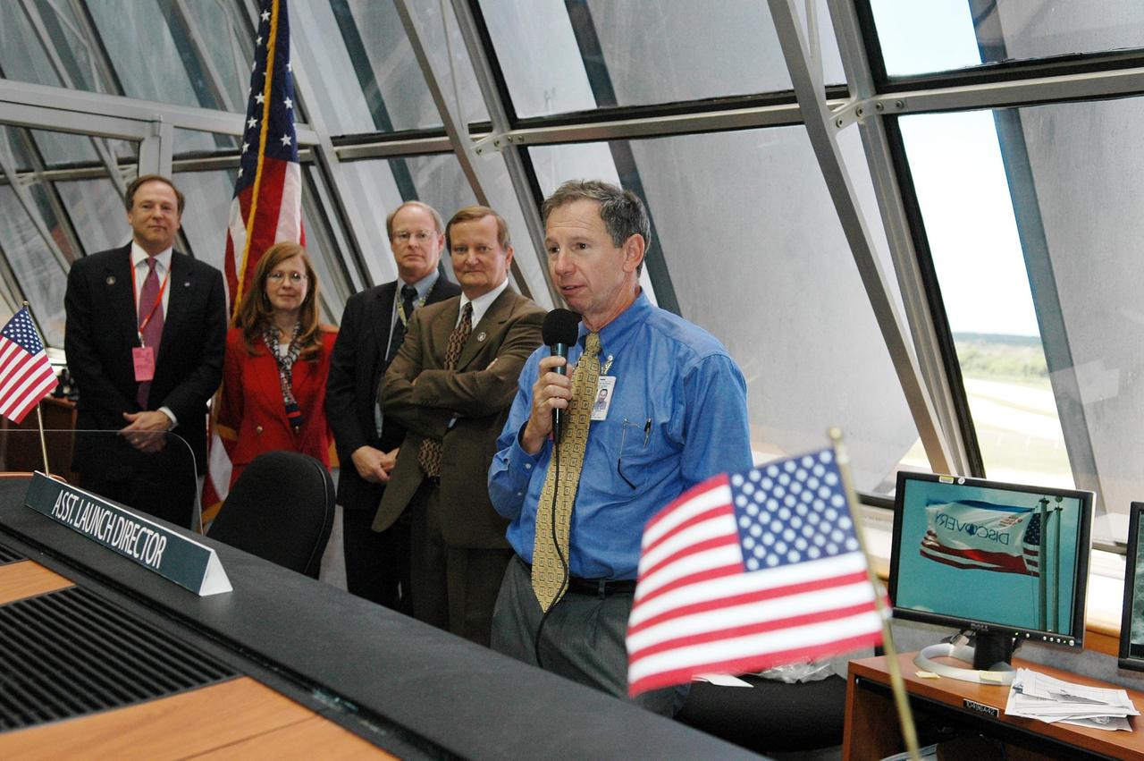 KENNEDY SPACE CENTER, FLA. -   In Firing Room 4 of the Launch Control Center, NASA Administrator Mike Griffin congratulates the launch team on the successful launch of Space Shuttle Discovery on mission STS-121.  The launch was the first ever to take place on Independence Day.  Liftoff was on-time at 2:38 p.m. EDT.  Others next to Griffin are (left to right) David R. Mould,  assistant administrator for NASA Public Affairs ; Lisa Malone, director of External Relations at Kennedy; Bruce Buckingham, news chief at the NASA News Center at Kennedy; and Mike Leinbach, Shuttle Program director.    During the 12-day mission, the STS-121 crew of seven will test new equipment and procedures to improve shuttle safety, as well as deliver supplies and make repairs to the International Space Station.  Landing is scheduled for July 16 or 17 at Kennedy's Shuttle Landing Facility.   Photo credit: NASA/Kim Shiflett