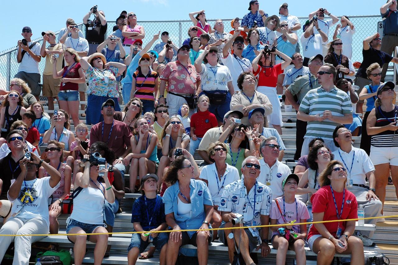 KENNEDY SPACE CENTER, FLA. - Visitors at the Kennedy Space Center's Banana River viewing site stay focused on the historic ride of Space Shuttle Discovery on mission STS-121 as it rockets into the blue sky for an historic launch -- the first ever on Independence Day. Liftoff was on-time at 2:38 p.m. EDT. During the 12-day mission, the STS-121 crew of seven will test new equipment and procedures to improve shuttle safety, as well as deliver supplies and make repairs to the International Space Station. Landing is scheduled for July 16 or 17 at Kennedy's Shuttle Landing Facility. Photo credit: NASA/Louie Roguevert