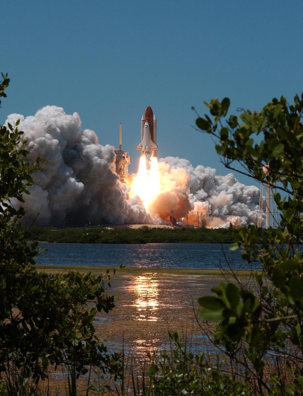 KENNEDY SPACE CENTER, FLA. - Space Shuttle Discovery kicks off the Fourth of July fireworks with its own fiery display as it rockets into the blue sky, spewing foam and smoke over the ground, on mission STS-121. It was the third launch attempt in four days; the others were scrubbed due to weather concerns. Liftoff was on-time at 2:38 p.m. EDT. During the 12-day mission, the STS-121 crew of seven will test new equipment and procedures to improve shuttle safety, as well as deliver supplies and make repairs to the International Space Station. Landing is scheduled for July 16 or 17 at Kennedy's Shuttle Landing Facility. Photo credit: NASA/Sandy Joseph, Robert Murray