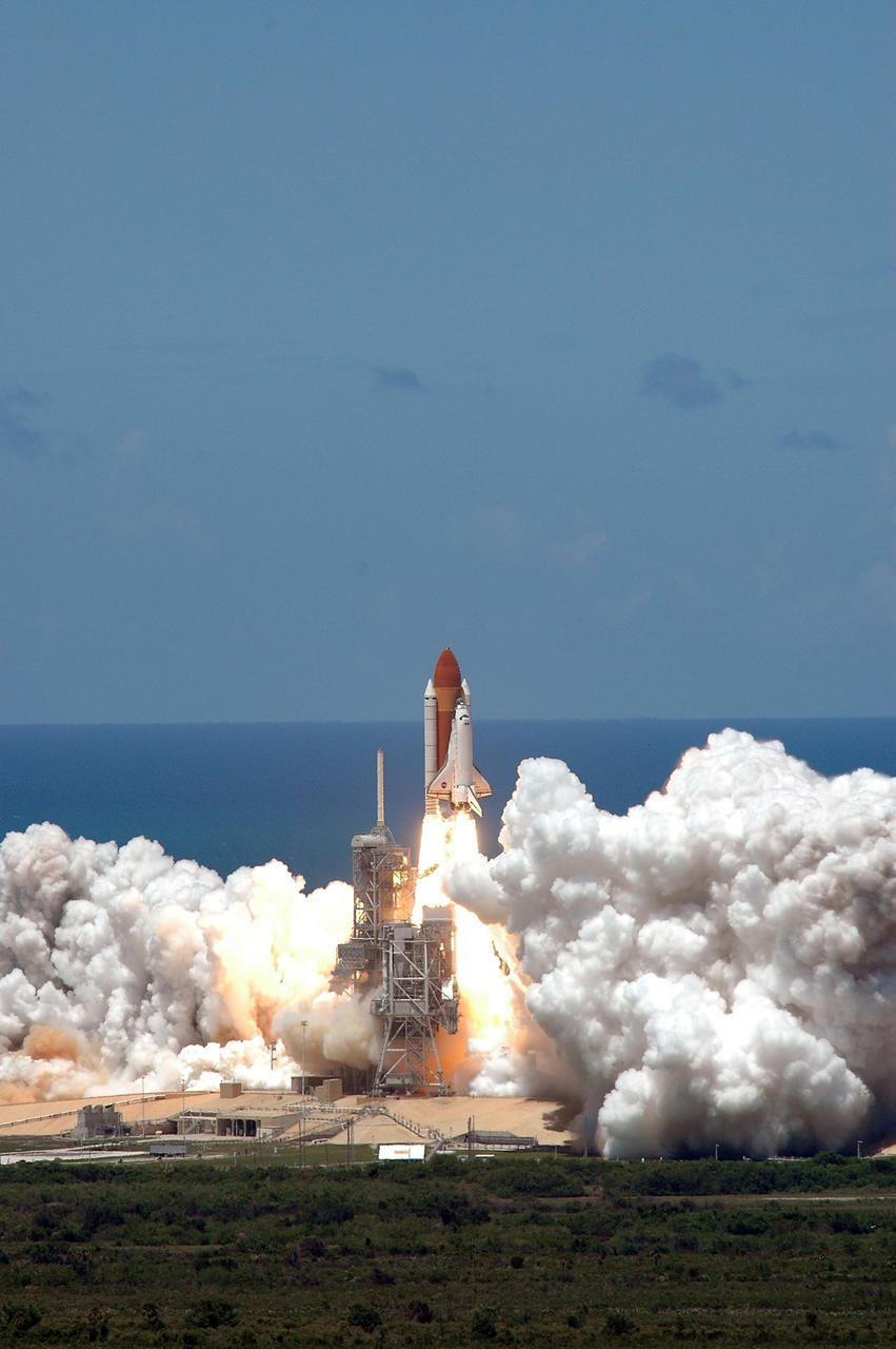KENNEDY SPACE CENTER, FLA. - Viewed from the top of the Vehicle Assembly Building at NASA's Kennedy Space Center, Space Shuttle Discovery kicks off the Fourth of July fireworks with its own fiery display as it rockets over the blue Atlantic Ocean and into the blue sky, spewing foam and smoke over the ground, on mission STS-121. It was the third launch attempt in four days; the others were scrubbed due to weather concerns. Liftoff was on-time at 2:38 p.m. EDT. During the 12-day mission, the STS-121 crew of seven will test new equipment and procedures to improve shuttle safety, as well as deliver supplies and make repairs to the International Space Station. Landing is scheduled for July 16 or 17 at Kennedy's Shuttle Landing Facility. Photo credit: NASA/Gianni Woods