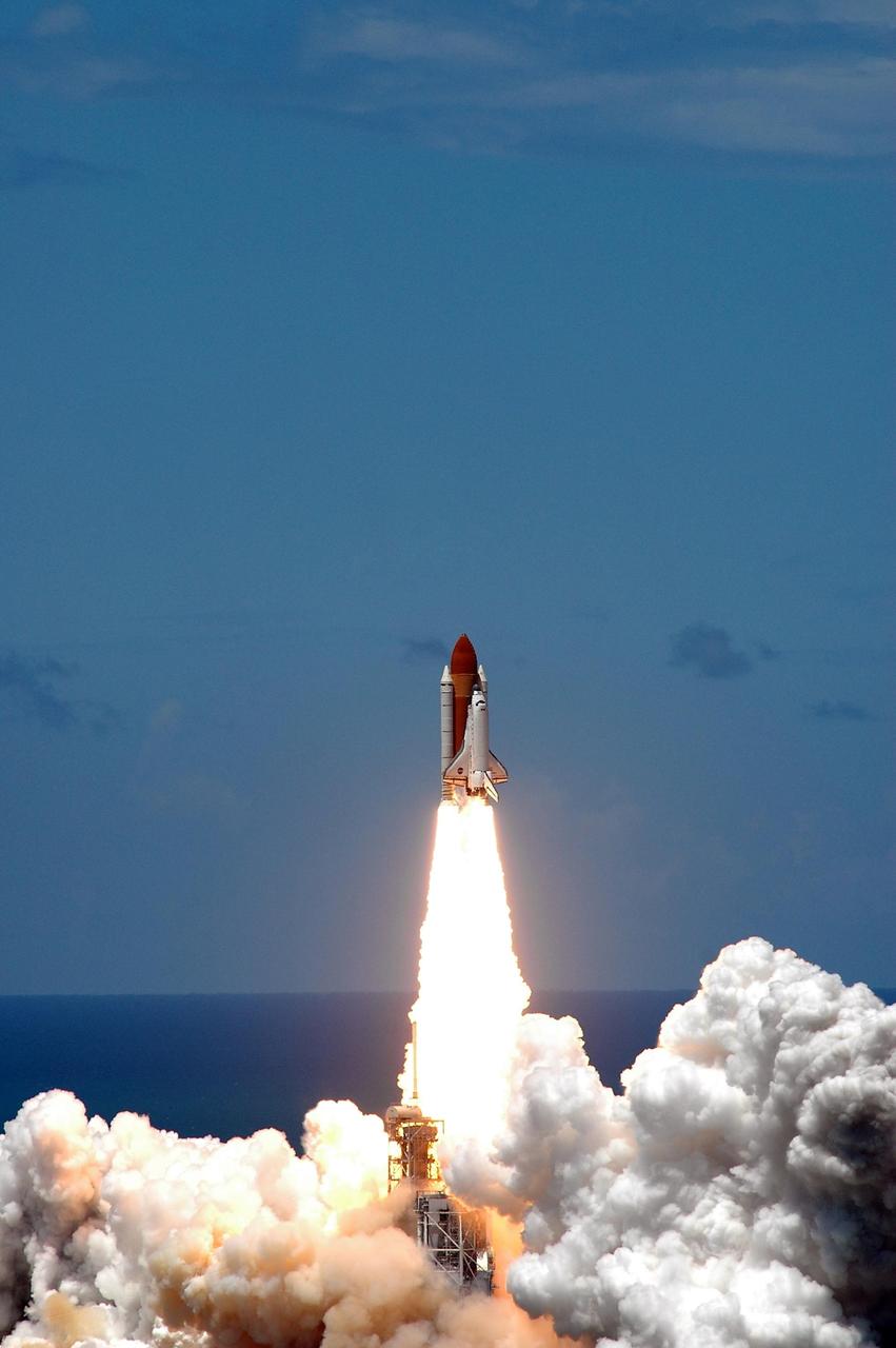 KENNEDY SPACE CENTER, FLA. -  Viewed from the top of the Vehicle Assembly Building at NASA's Kennedy Space Center, Space Shuttle Discovery shoots like a roman candle into the blue sky, kicking off the Fourth of July fireworks with its own fiery display.  It was the third launch attempt in four days; the others were scrubbed due to weather concerns.  Liftoff was on-time at 2:38 p.m. EDT.  During the 12-day mission, the STS-121 crew of seven will test new equipment and procedures to improve shuttle safety, as well as deliver supplies and make repairs to the International Space Station.  Landing is scheduled for July 16 or 17 at Kennedy's Shuttle Landing Facility.    Photo credit: NASA/Gianni Woods