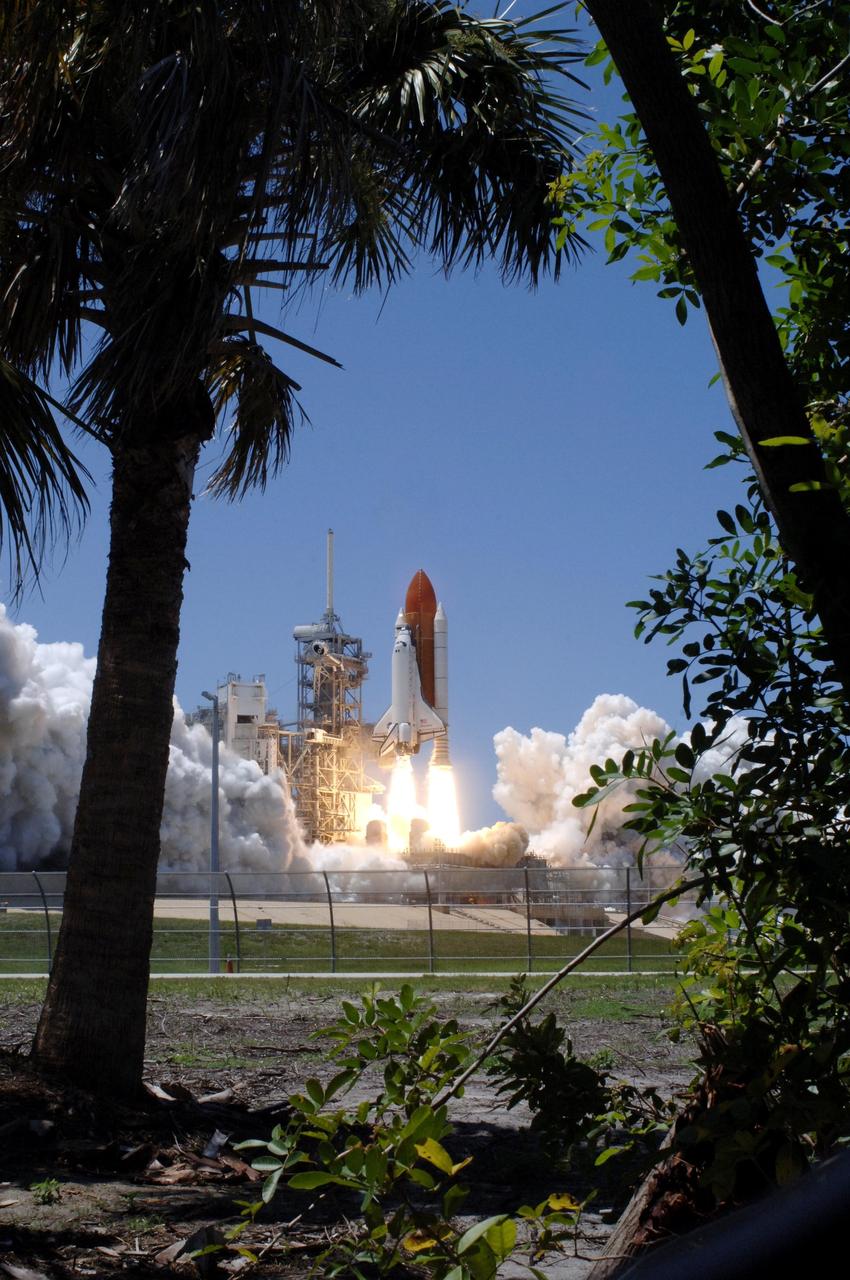 KENNEDY SPACE CENTER, FLA. - Framed by palm trees, Space Shuttle Discovery lifts off Launch Pad 39B at 2:38 p.m. EDT. The fiery display fit the day: Fourth of July. The launch made history as it was the first ever launch on Independence Day. During the 12-day mission, the STS-121 crew of seven will test new equipment and procedures to improve shuttle safety, as well as deliver supplies and make repairs to the International Space Station. Landing is scheduled for July 16 or 17 at Kennedy's Shuttle Landing Facility. Photo credit: NASA/Sandy Joseph, Robert Murray